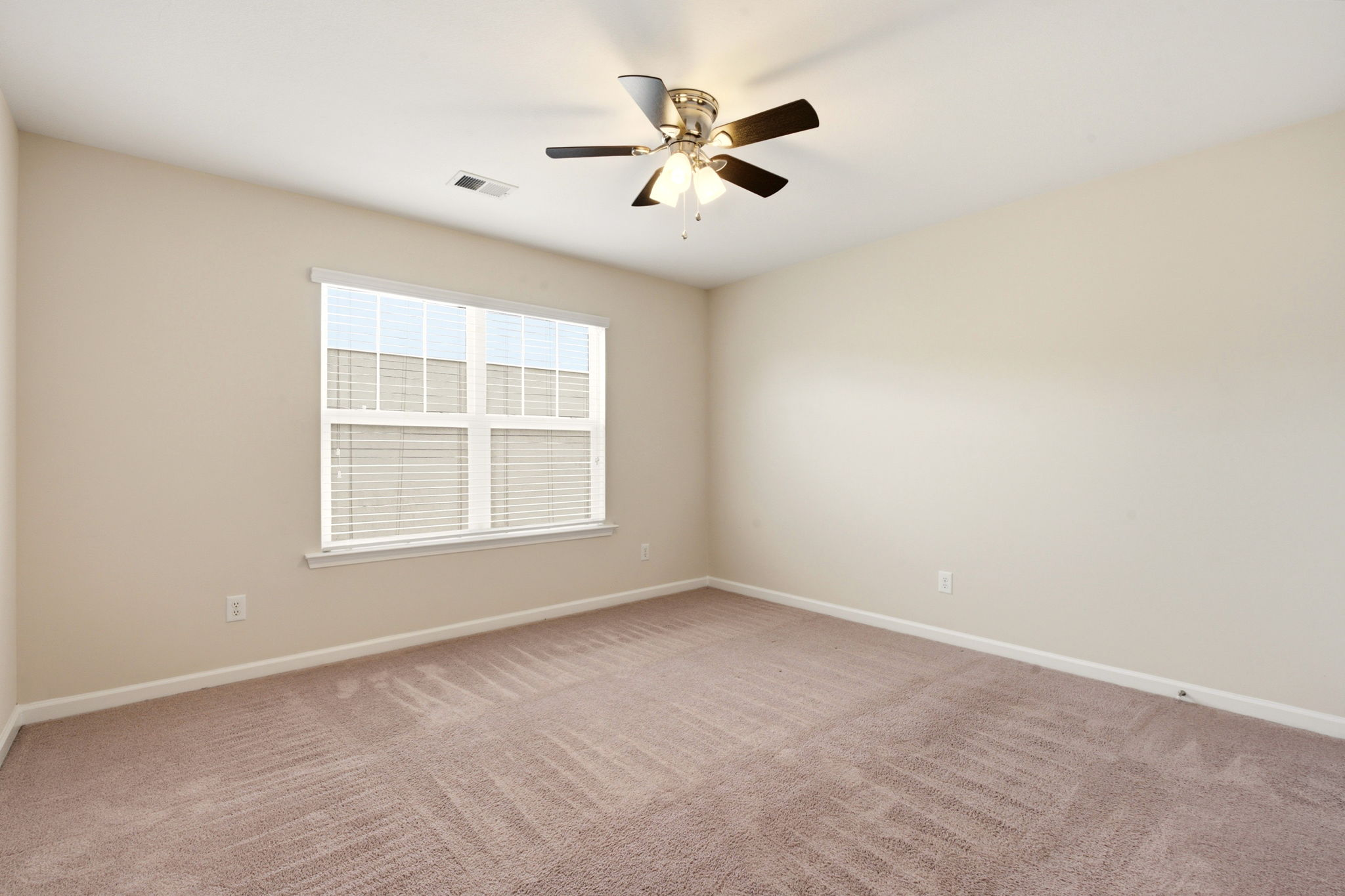 Spare bedroom upstairs with carpet and large window, ready for guests or office