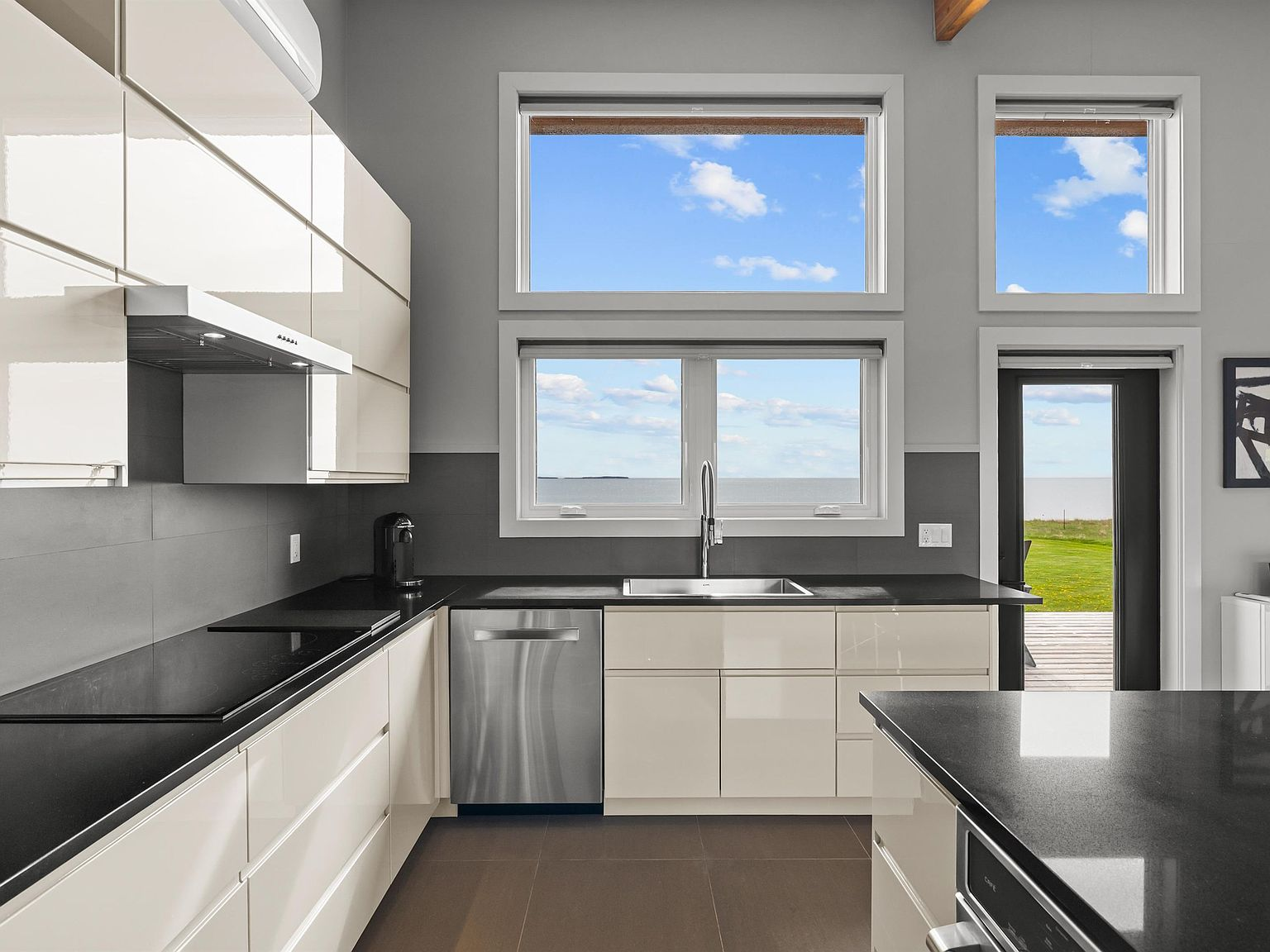Chef's kitchen with black quartz countertops and ocean-facing windows