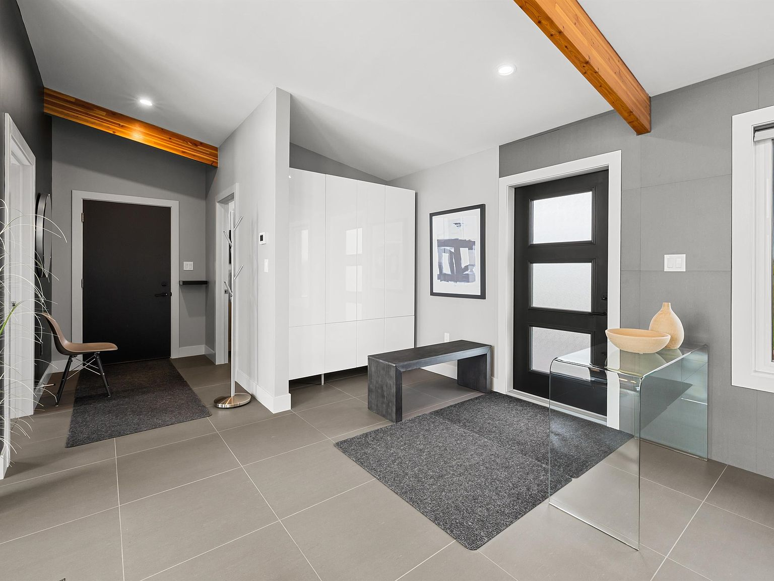Contemporary entry foyer with porcelain tile and exposed beams