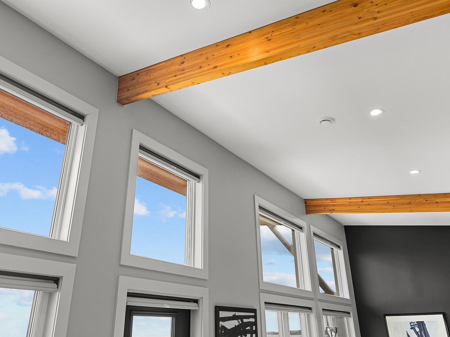 Living area with high-reaching windows and exposed wood beams