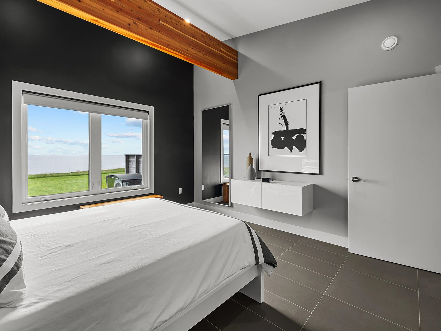 Master bedroom with exposed wood beam and water view