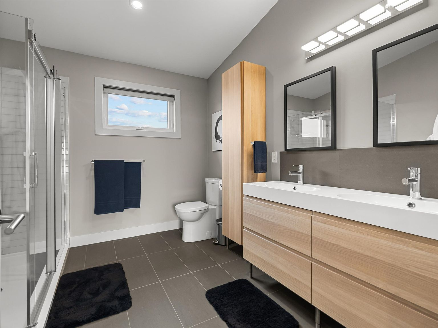 Master ensuite with walk-in shower and light wood vanity