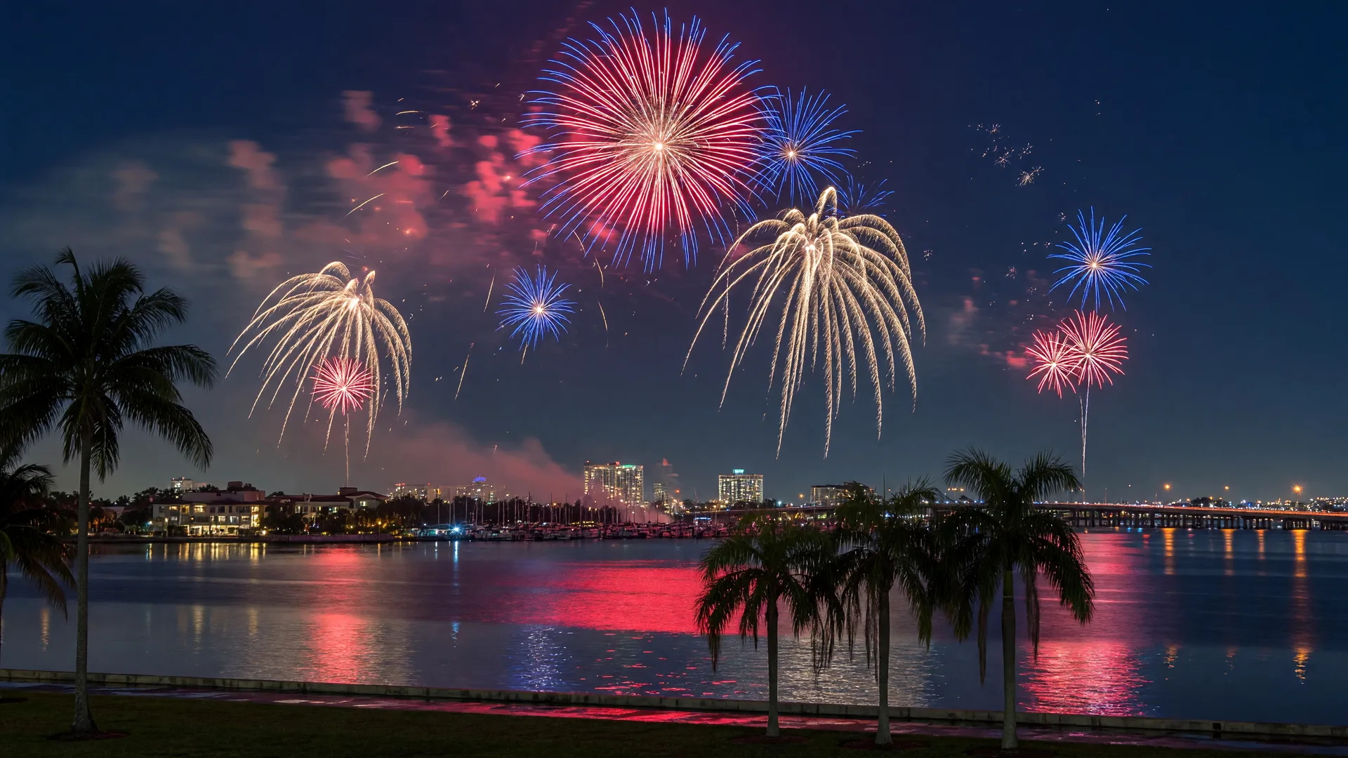 Fireworks exploding over a Southwest Florida waterfront at night