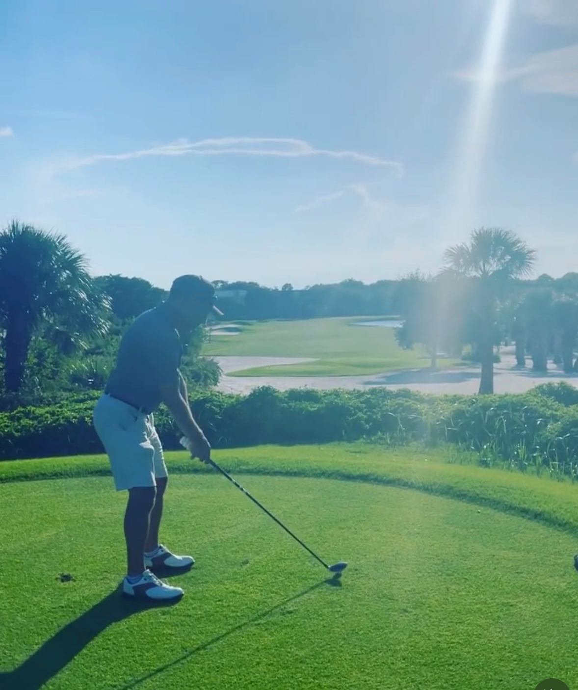 Alex Haigh on an elevated tee box with a scenic course view behind