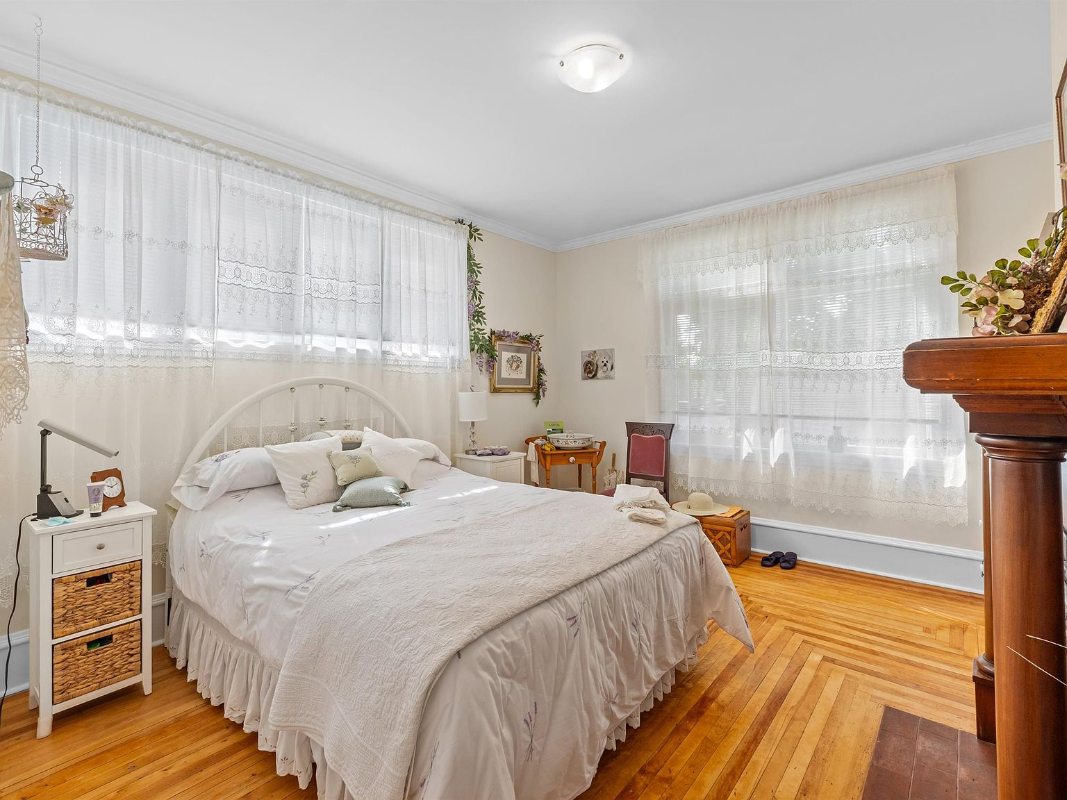 Bedroom with hardwood floors and classic wooden mantelpiece