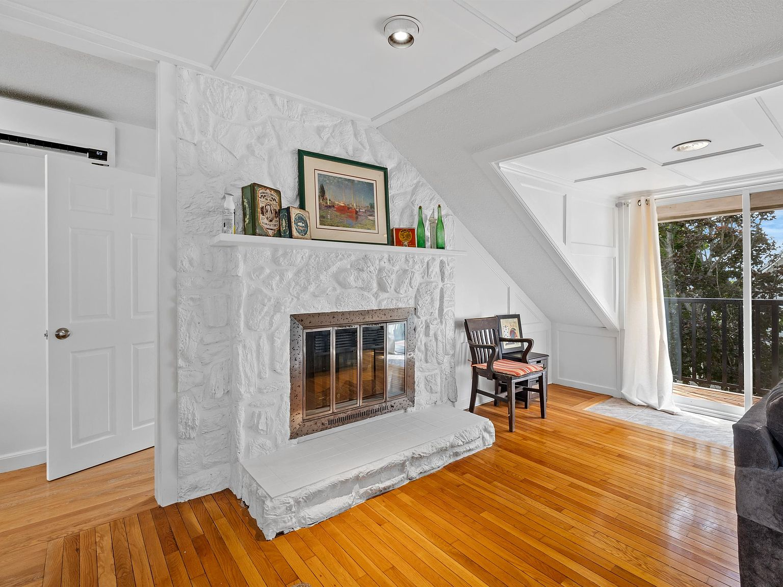 Living room with whitewashed stone fireplace and tray ceiling