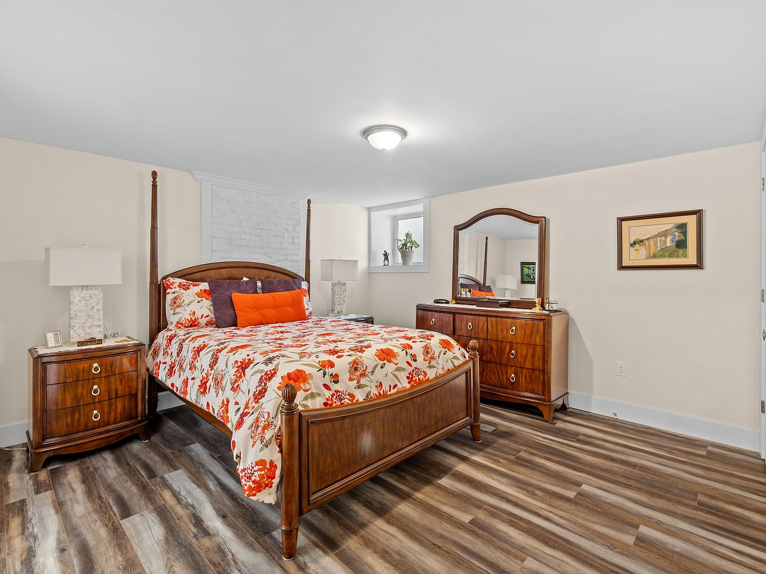 Bedroom with four-poster bed frame and painted brick detail