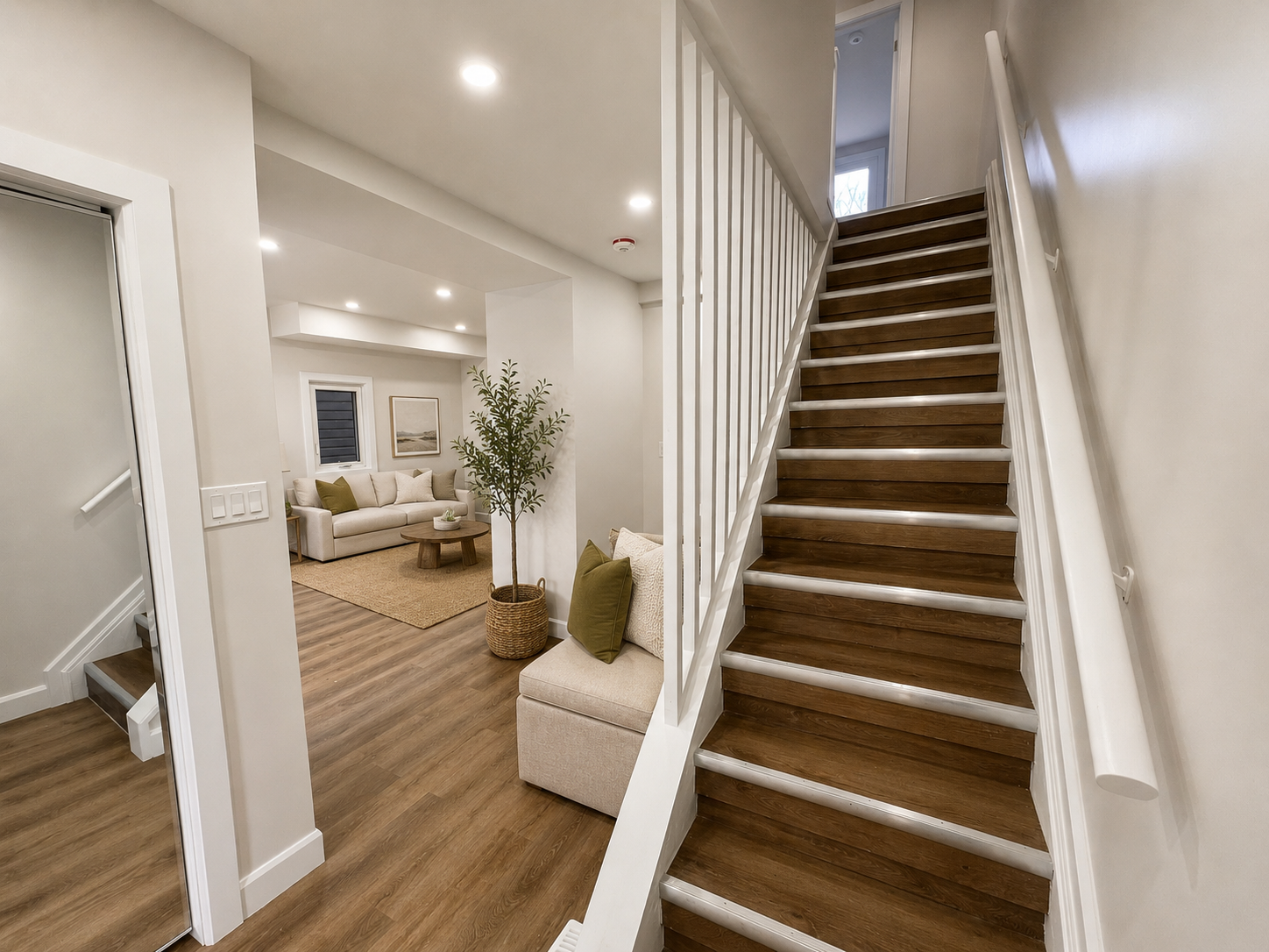Main floor view showing staircase and partial living area with wood-tread stairs