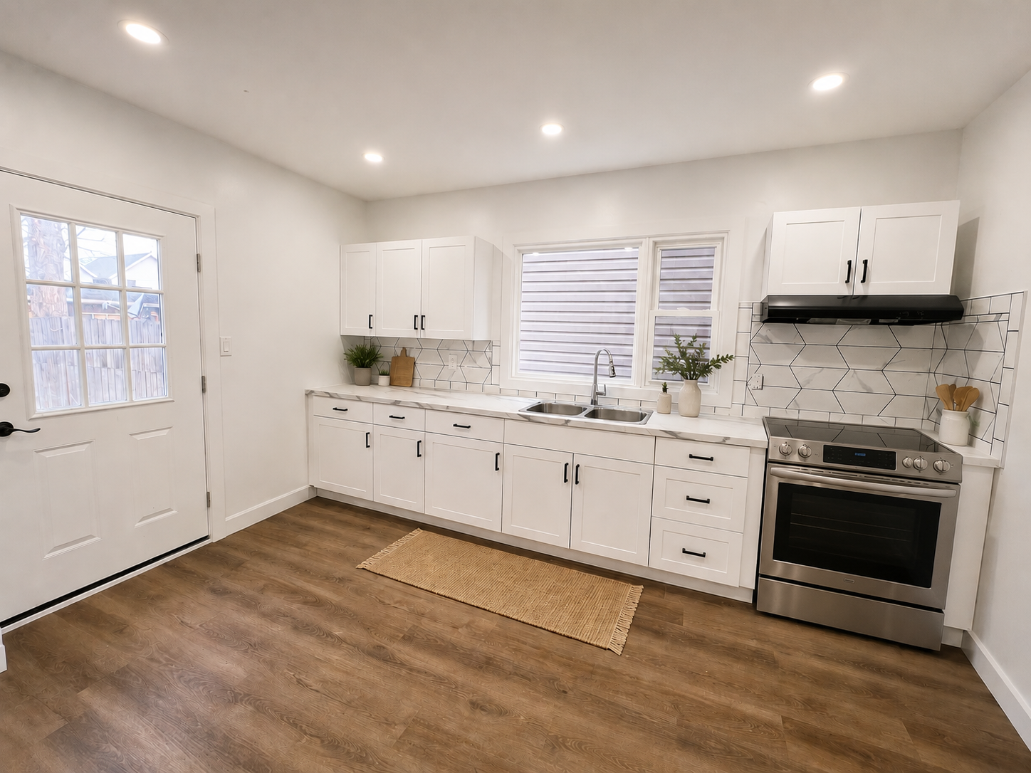 Kitchen with white shaker cabinets and marble-look backsplash