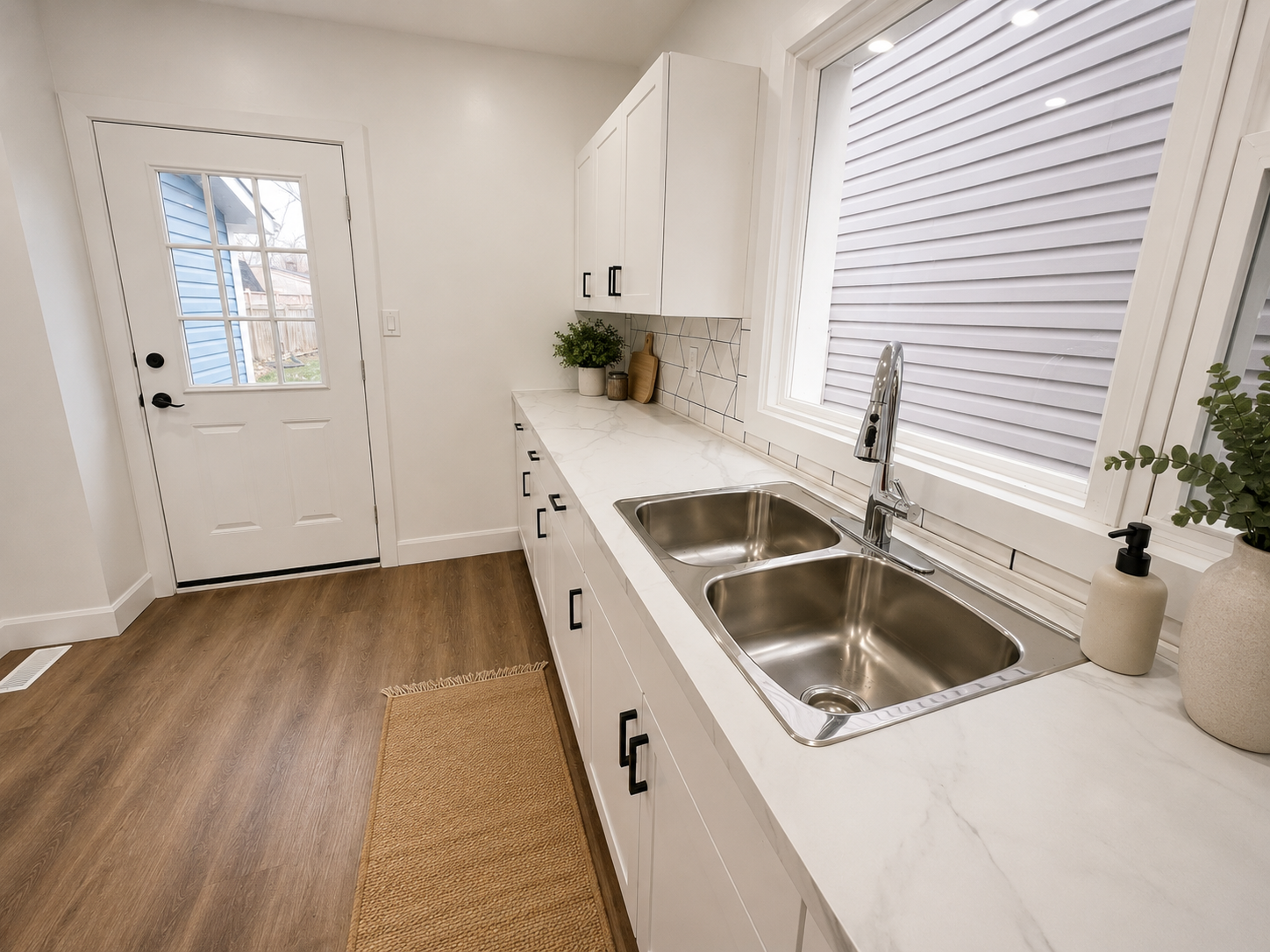 Kitchen counter with white faux-marble quartz counters and geometric tile backsplash
