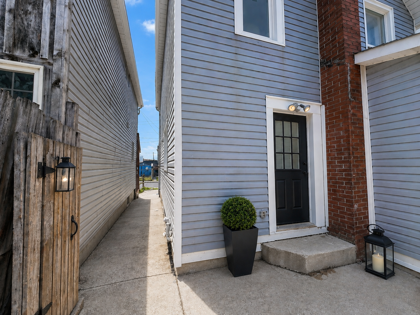 Side entrance with light blue siding and red brick chimney detail