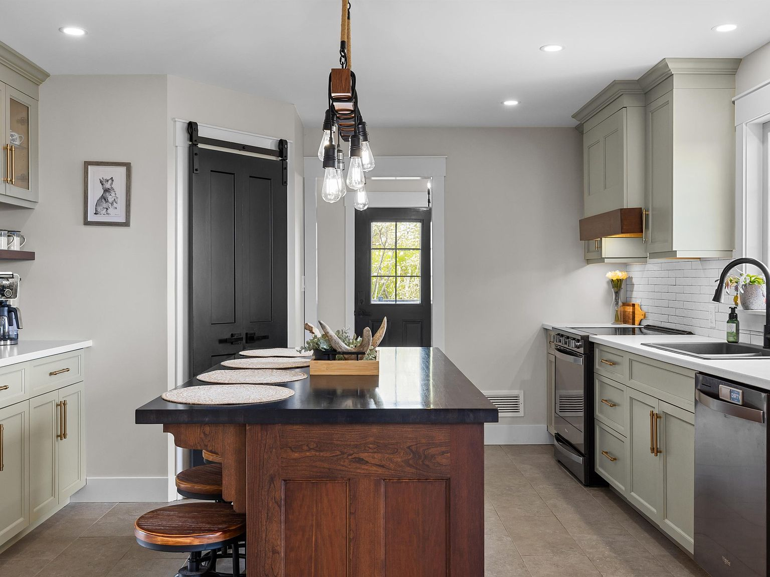 Chef's kitchen with sage green cabinets, wood-tone island, and designer finishes