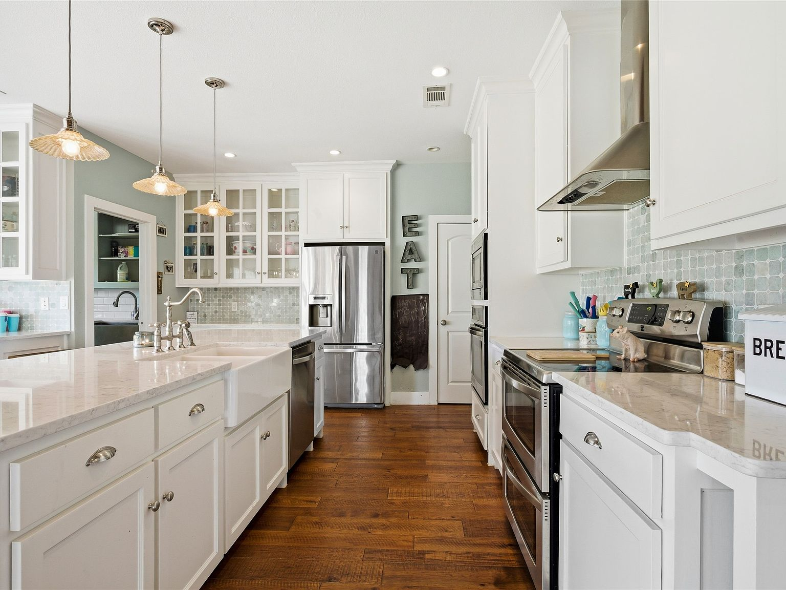 Modern farmhouse kitchen with white cabinetry, quartz counters, and teal glass tile backsplash