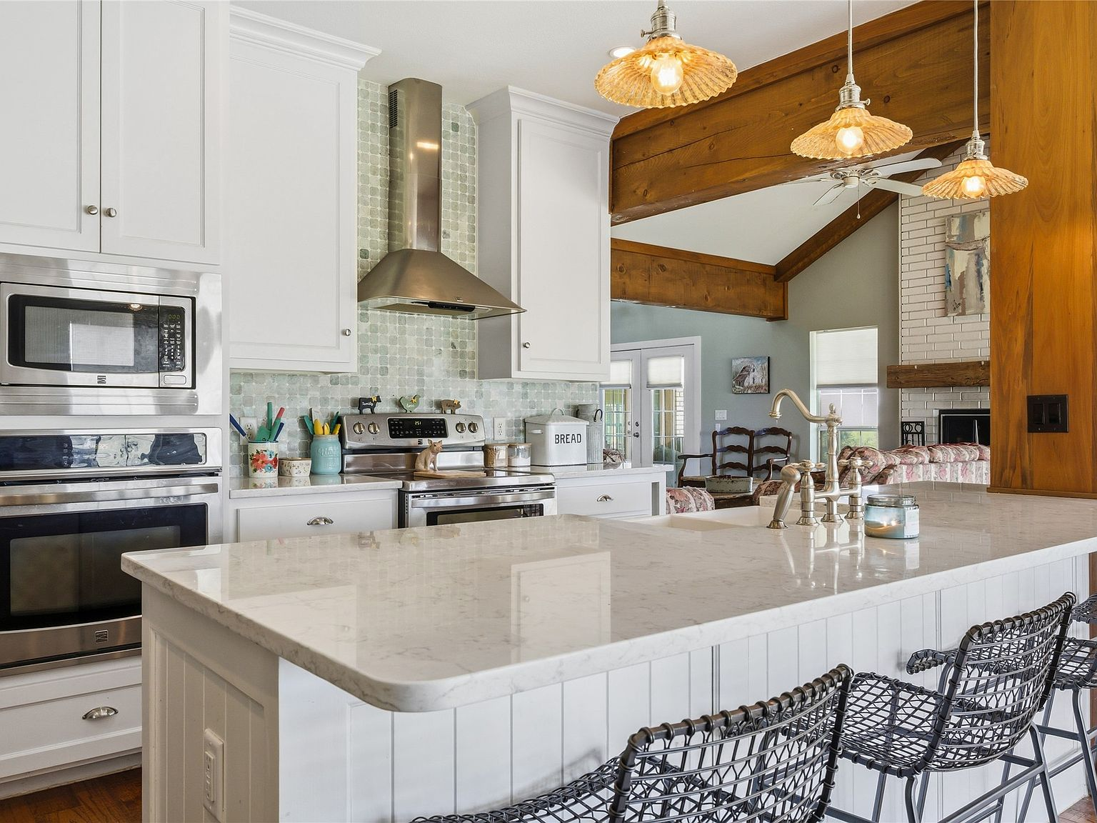 Modern farmhouse kitchen with quartz countertops, white cabinetry, and exposed wood beams