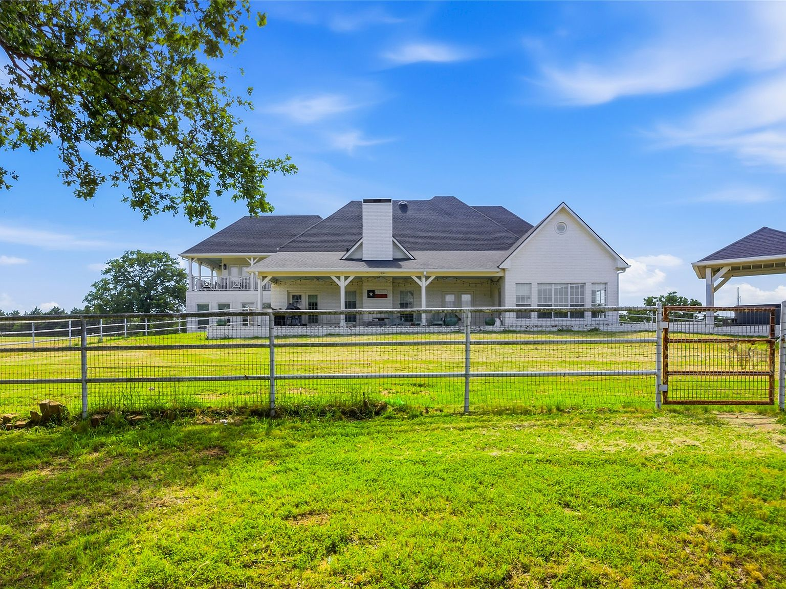 Rear view of the modern farmhouse with expansive covered back porch