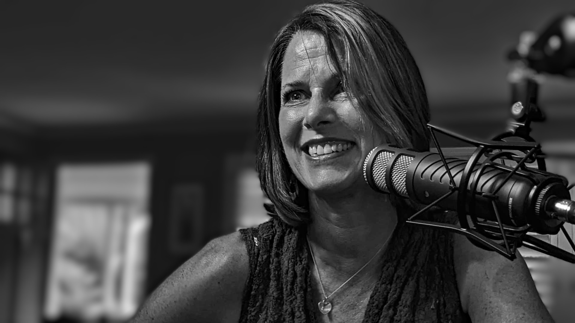 Sharon Glatz Scott speaking into a professional studio microphone