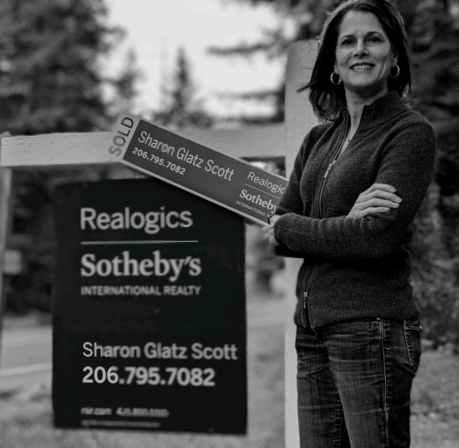 Sharon Glatz Scott stands with arms crossed beside a sold Sotheby's real estate sign