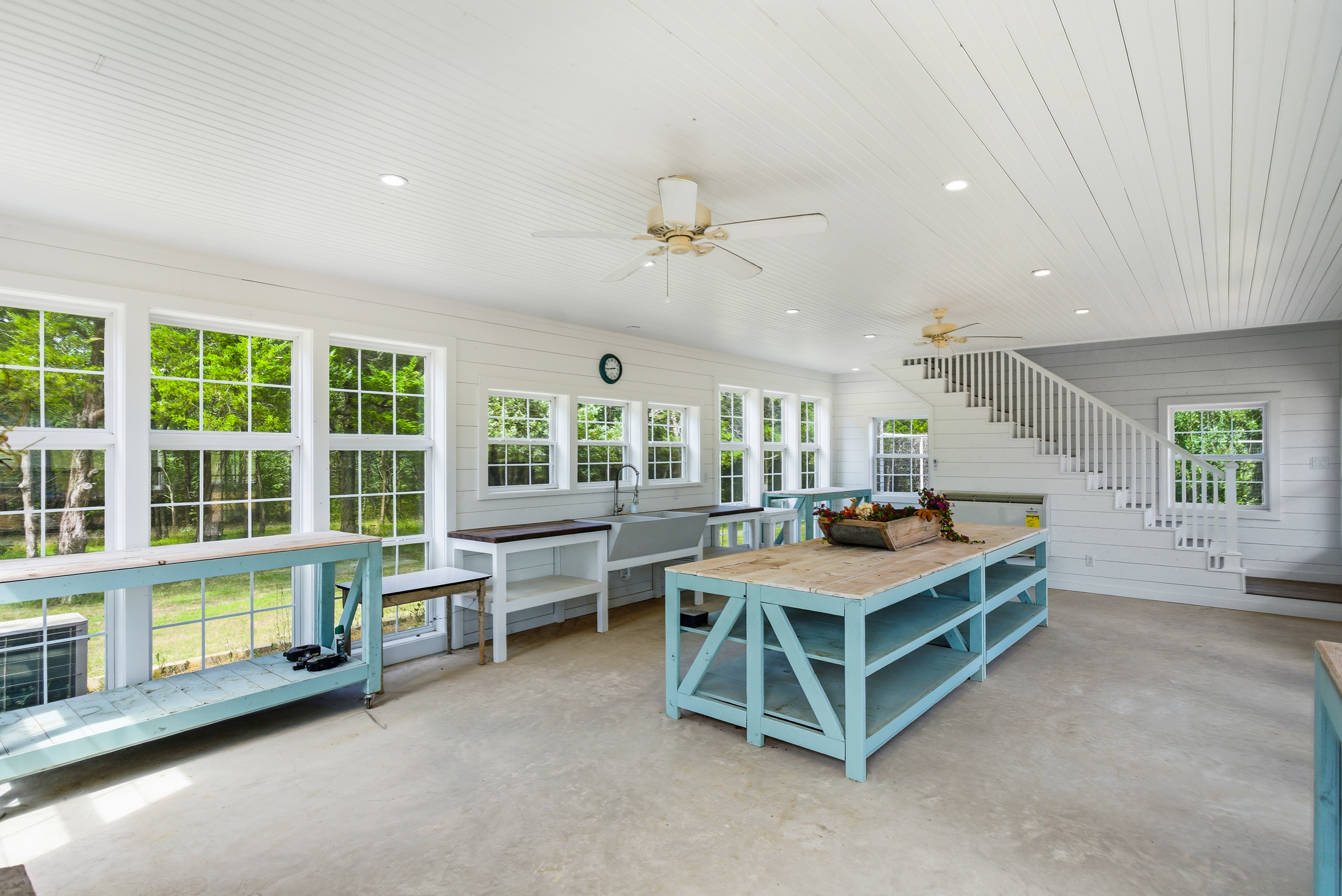Guest cottage ground level studio with shiplap walls and custom work tables