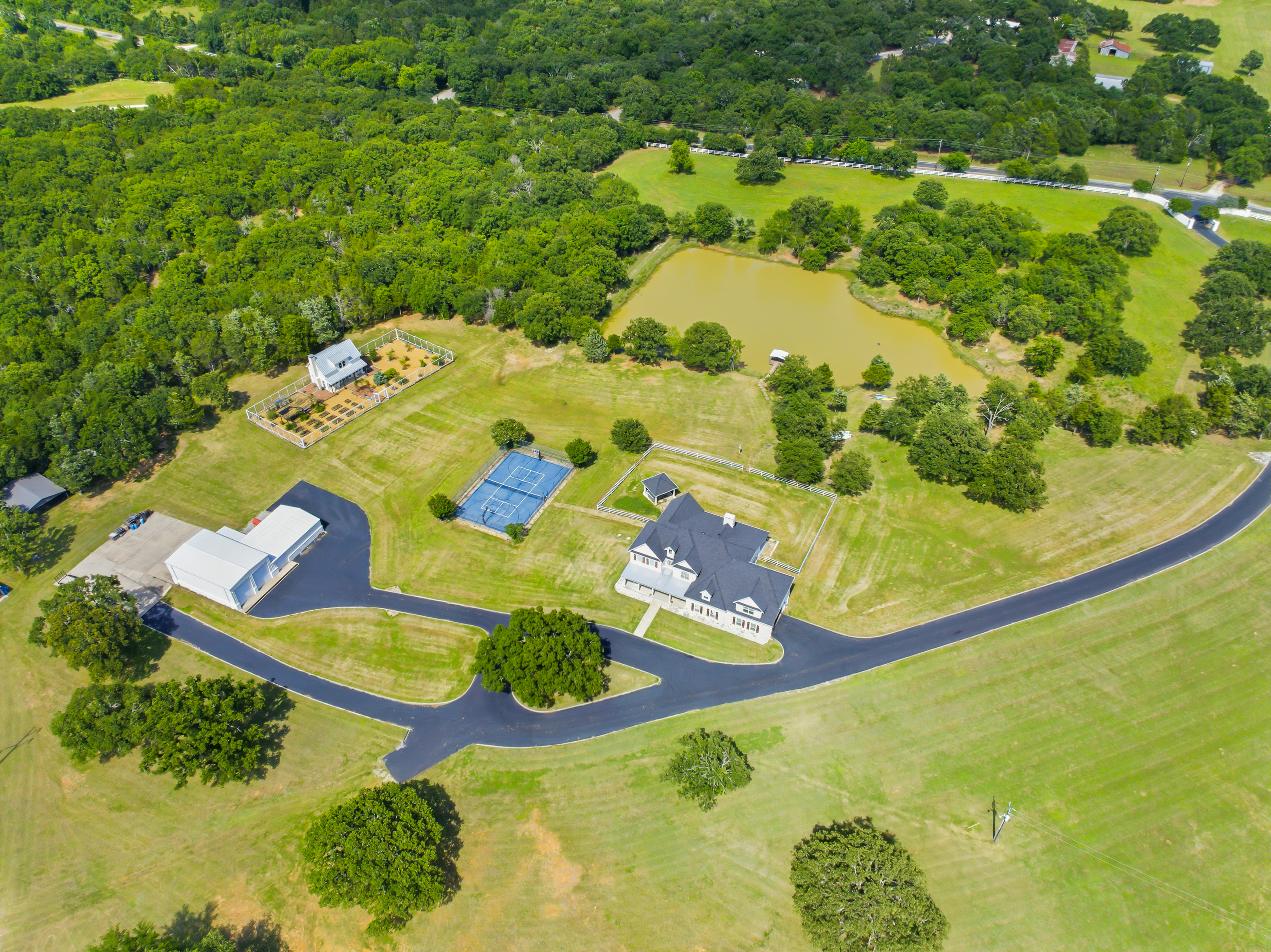Aerial view of the full 50-acre property with multiple structures and mature tree canopy