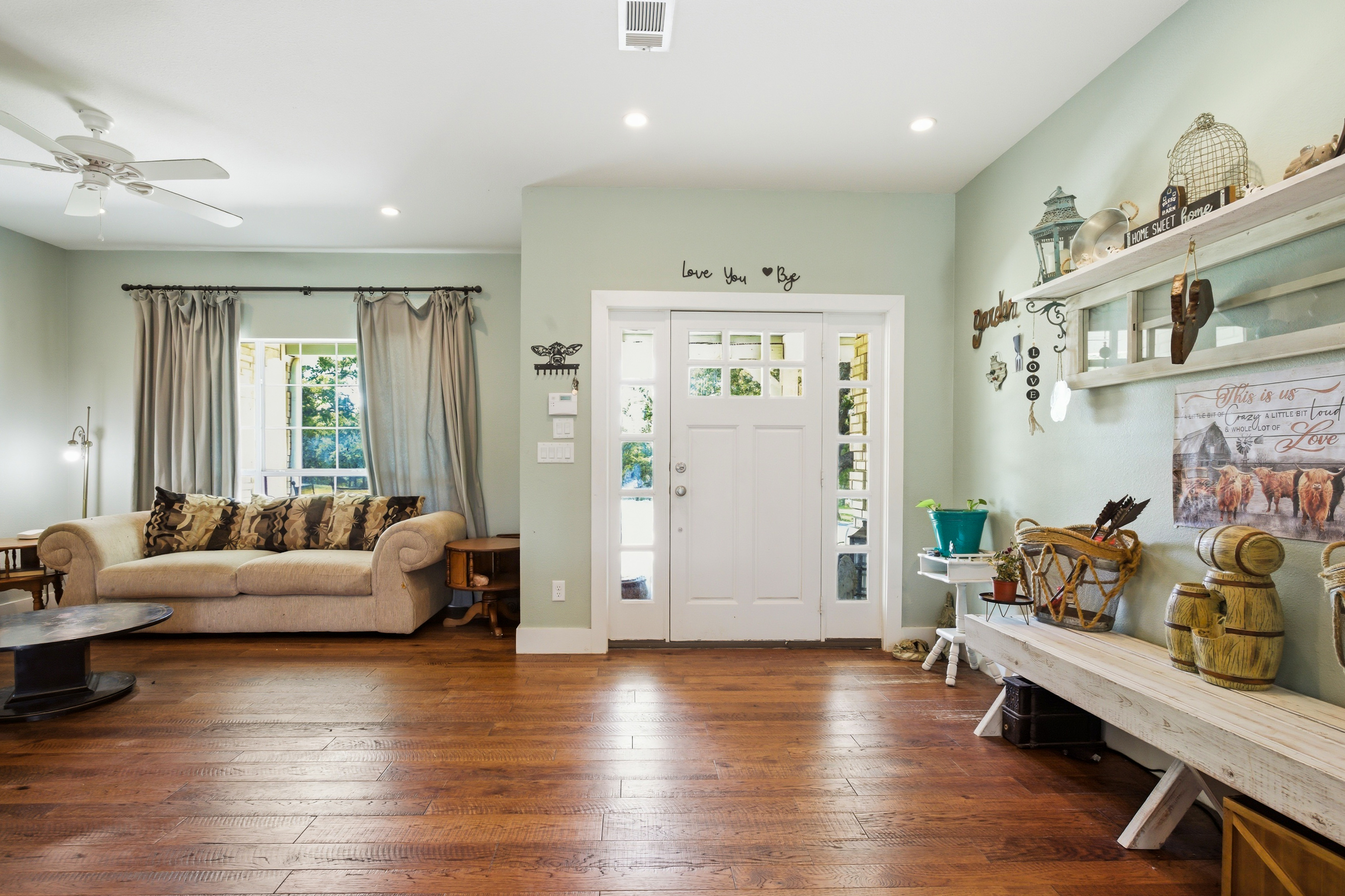Grand 43-foot entry room extending across the full width of the home, with hardwood floors and natural light