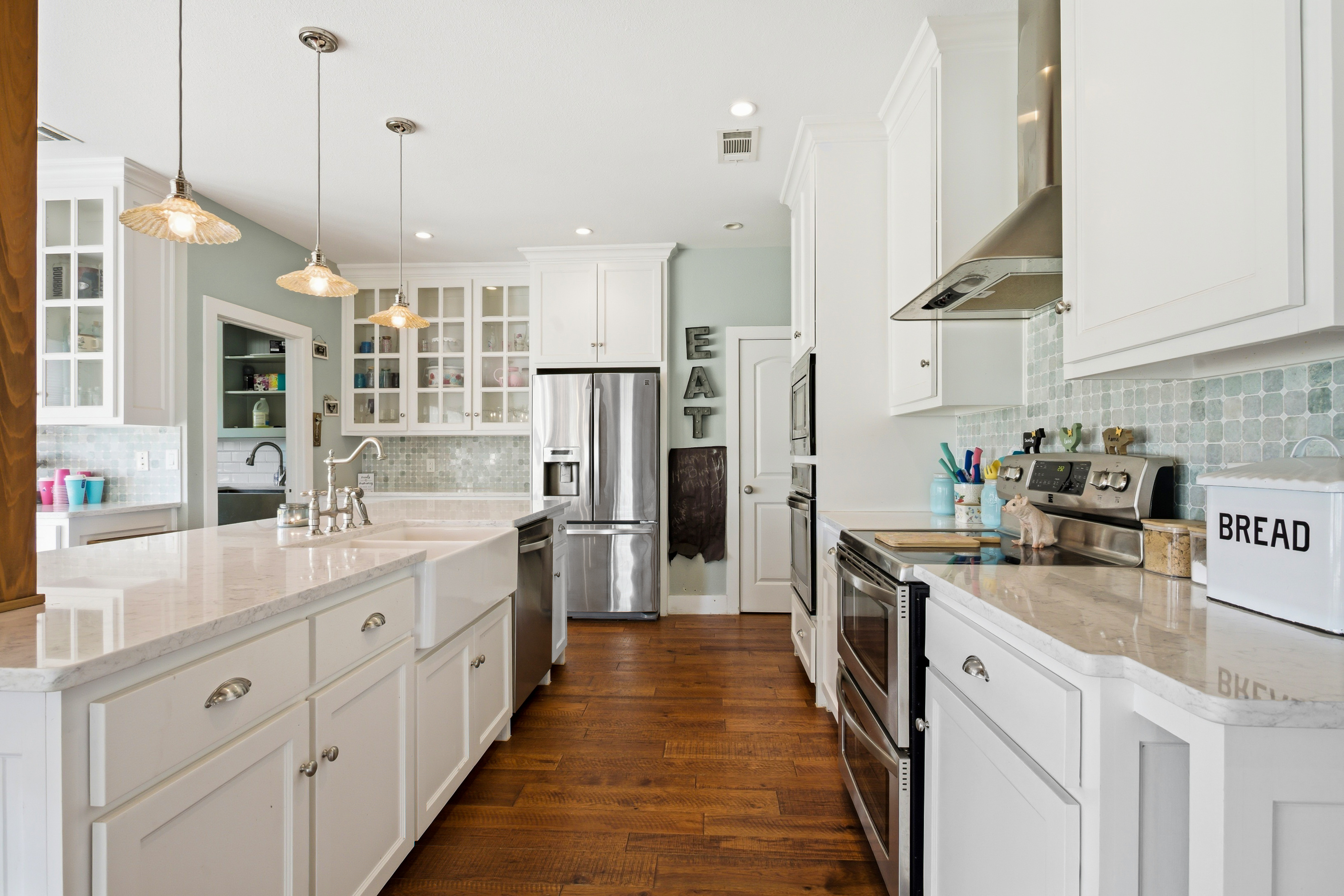 Kitchen view with white cabinetry, mosaic tile backsplash, and stainless steel appliances