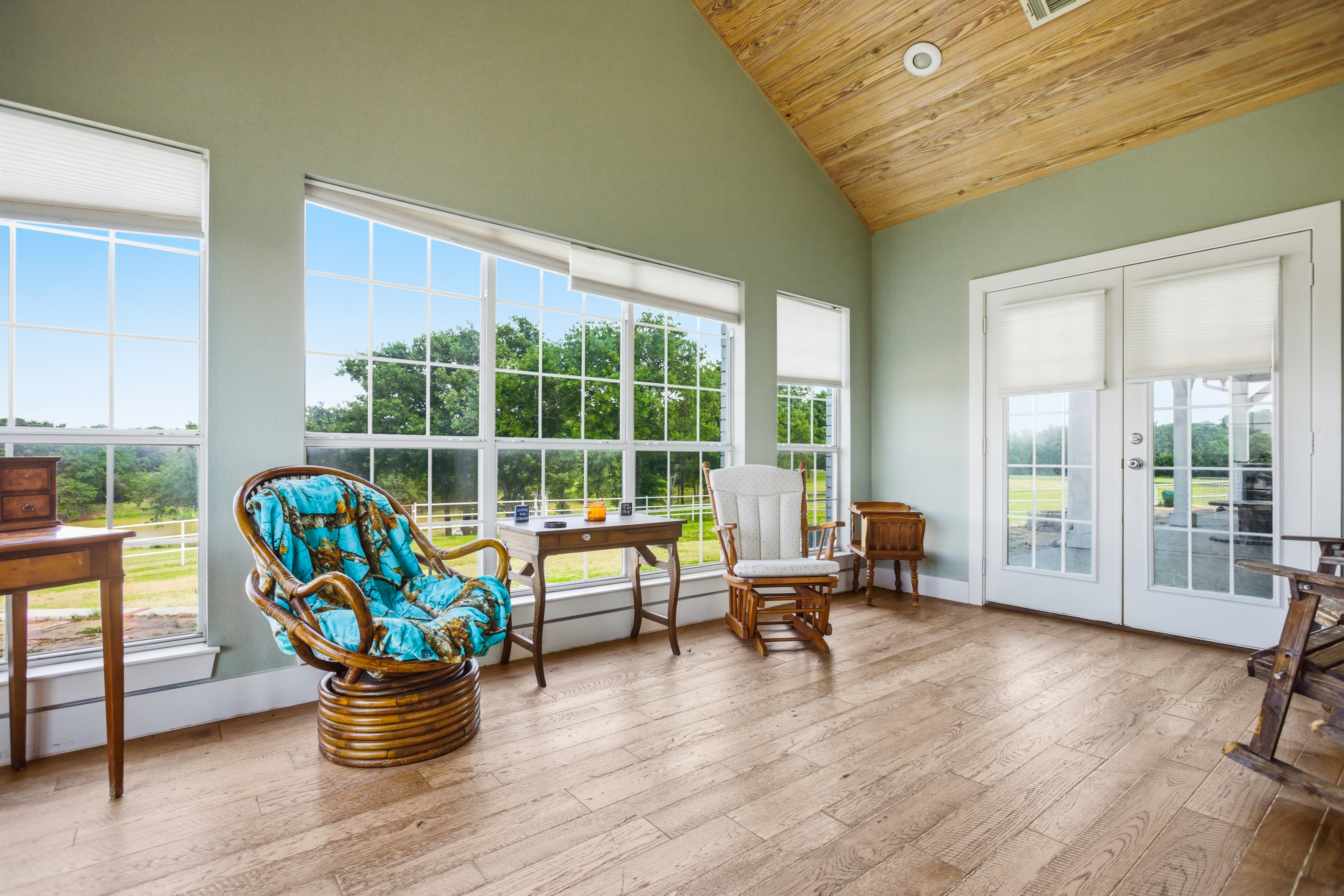Enclosed sunroom with vaulted ceilings and floor-to-ceiling pond views