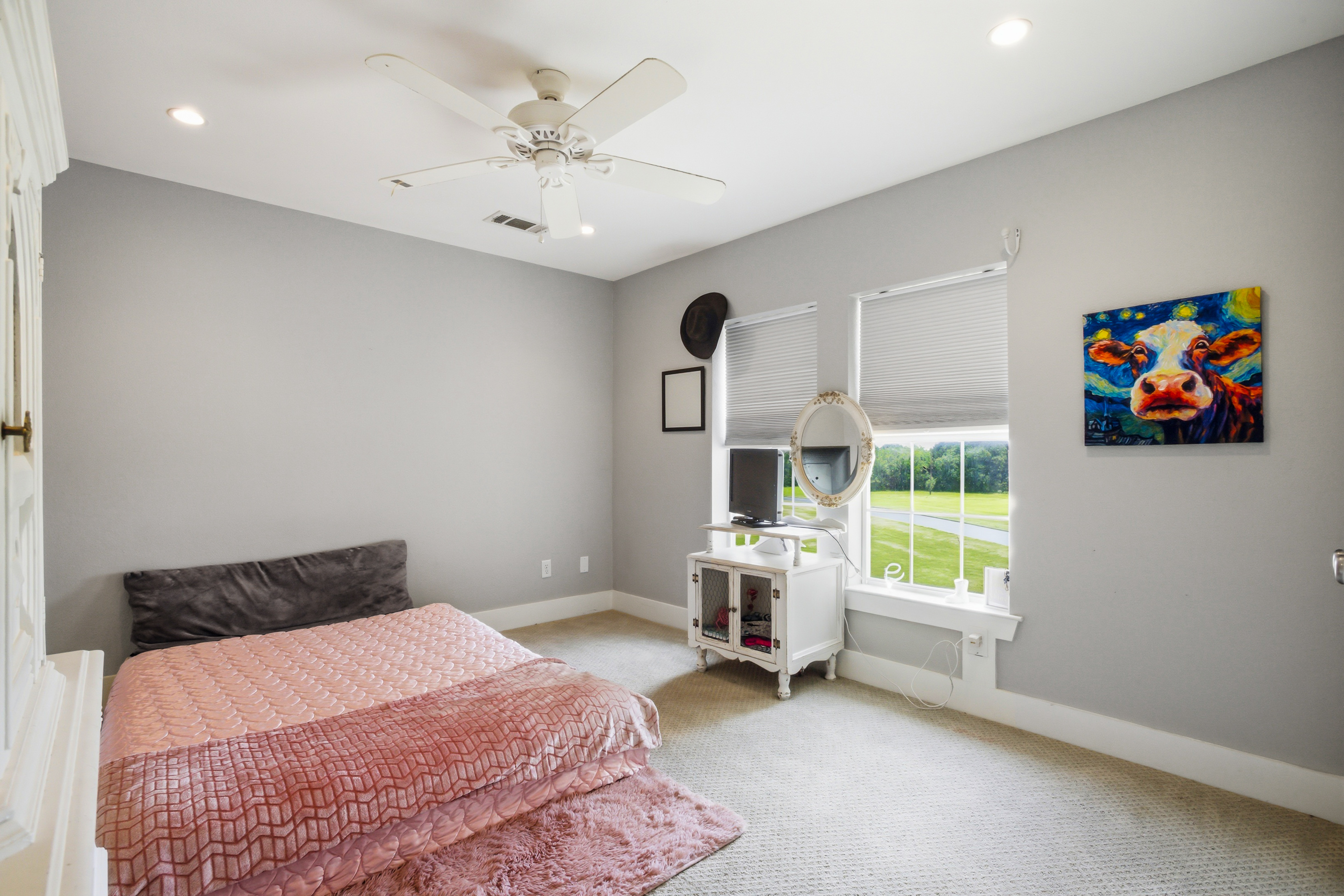 Secondary bedroom suite with neutral carpet and natural daylight from two windows