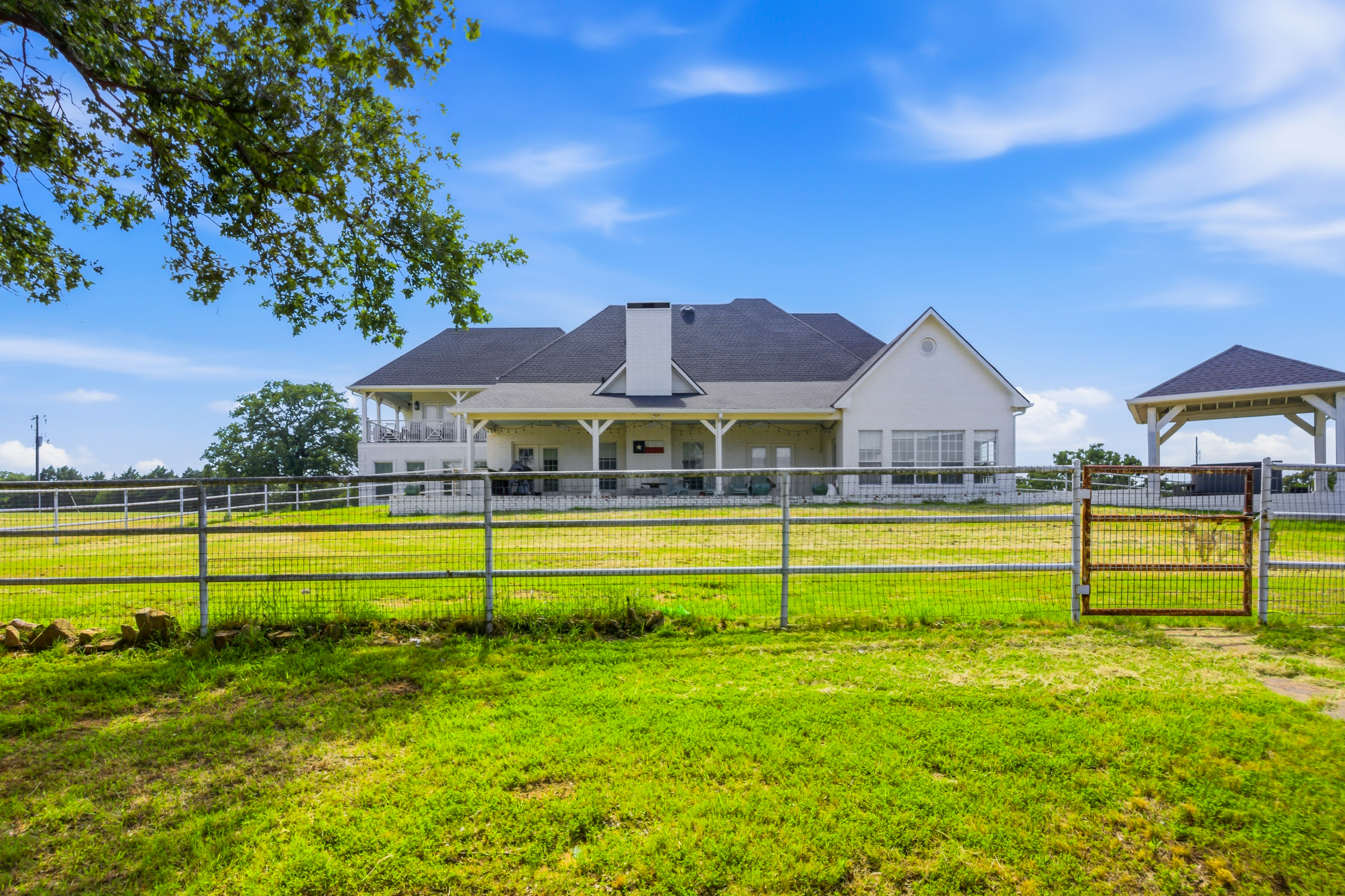 Rear exterior with wrap-around patio and high-pitched roof lines