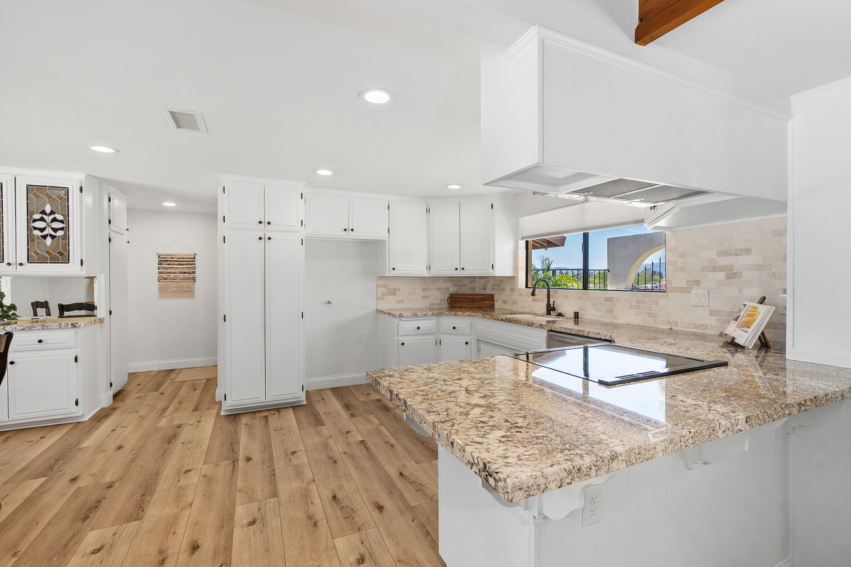 Remodeled kitchen with white shaker cabinets and granite countertops