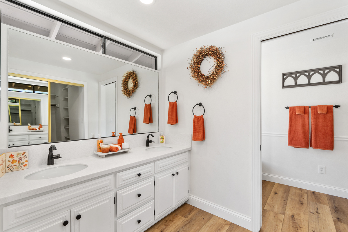 Updated bathroom with double vanity and white cabinetry