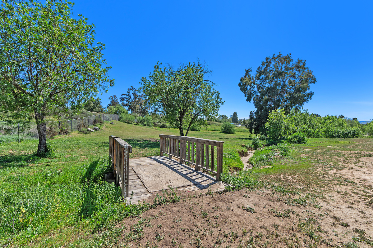 Rustic wooden footbridge crossing the seasonal creek on the property