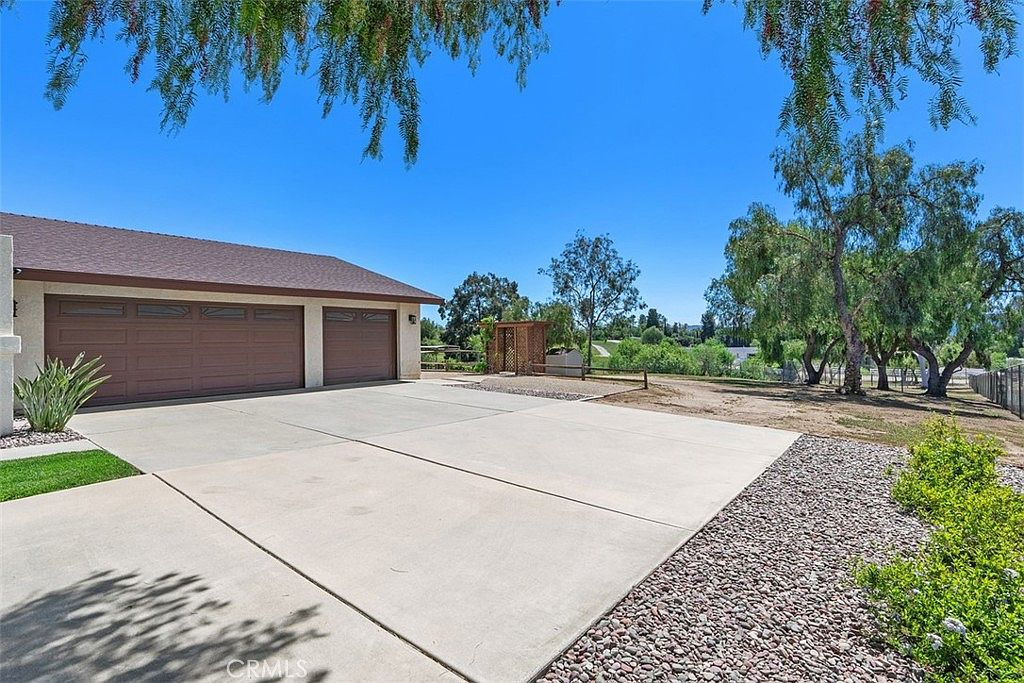 Three-car garage with gravel landscaping and no formal driveway