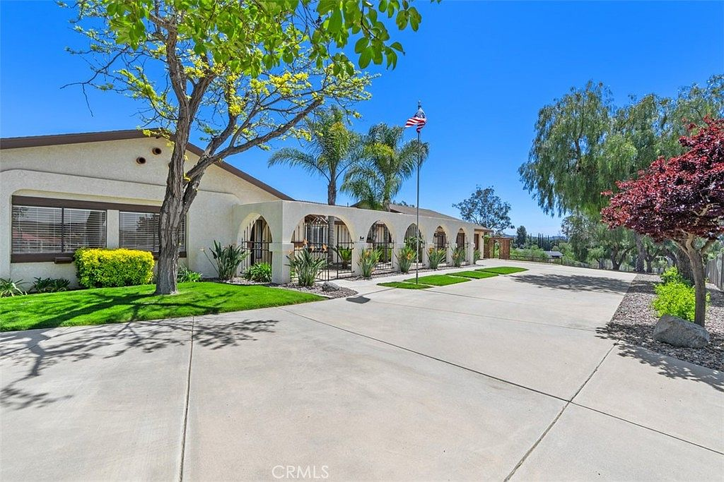 37790 Los Alamos Rd — ranch-style estate facade with arched entryways under a clear blue sky
