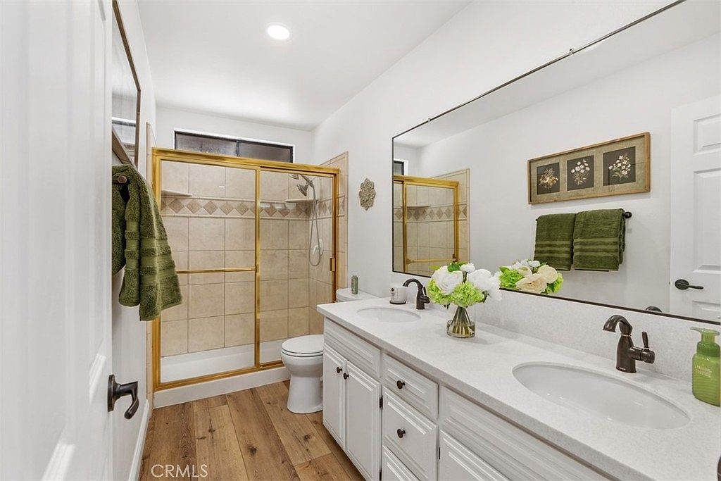 Bathroom with dual vanity and gold shower frame