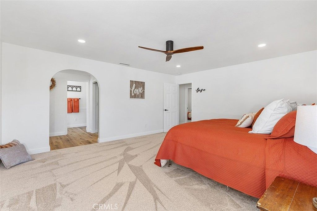 Primary bedroom with view into wood-floored bathroom