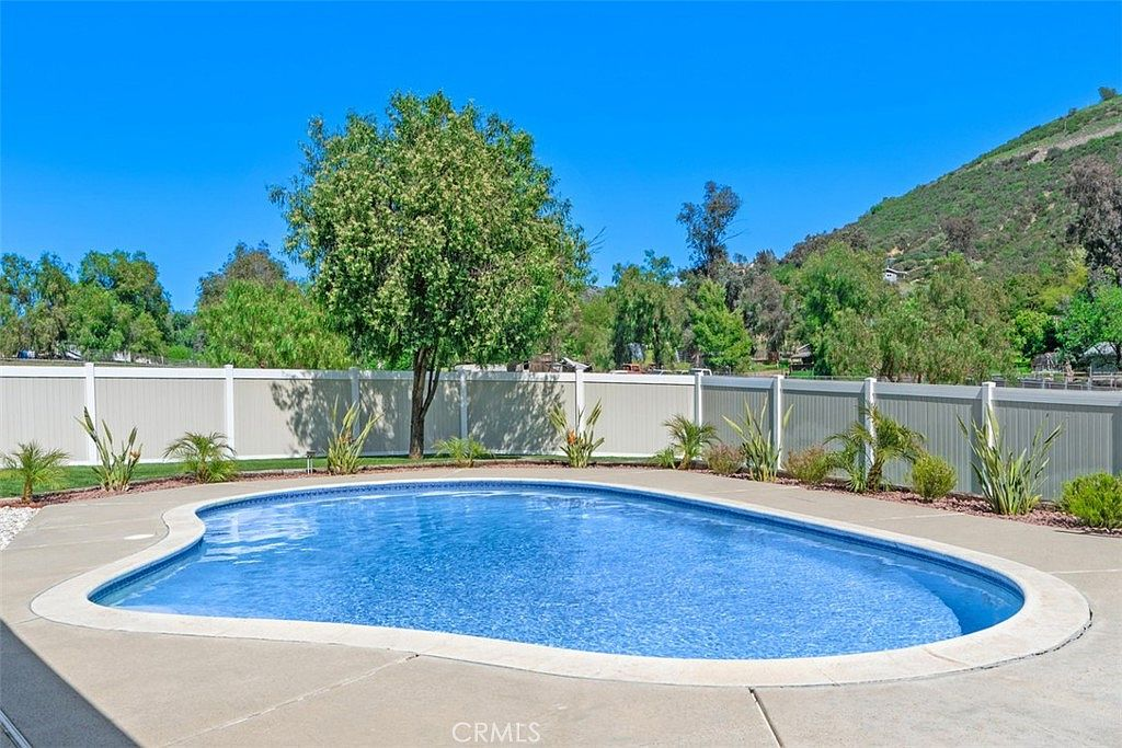 Private backyard oasis with swimming pool, wooden cabana, and professional landscaping