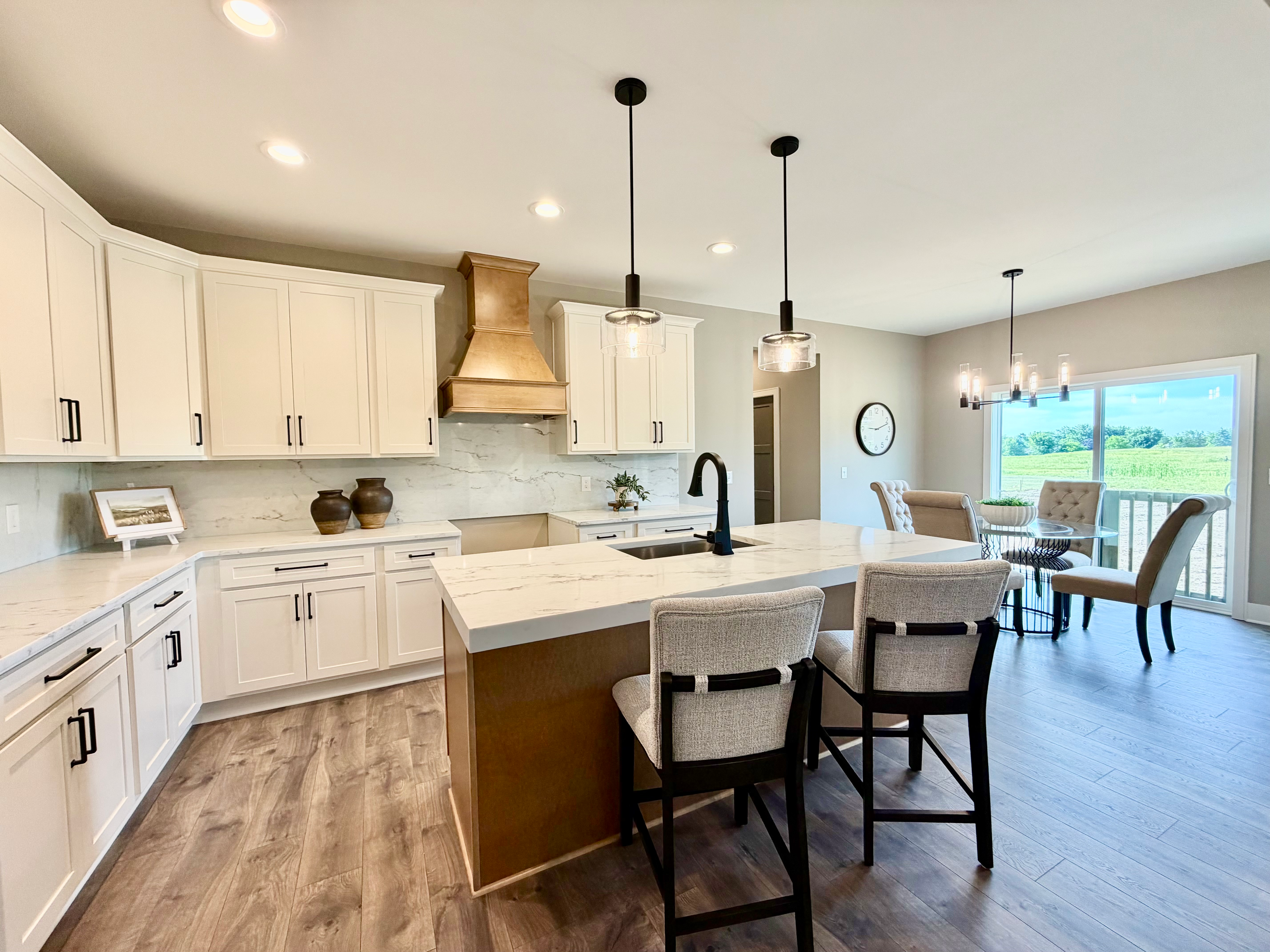 Open-concept custom kitchen with white shaker cabinets, an island, and natural light from sliding glass doors