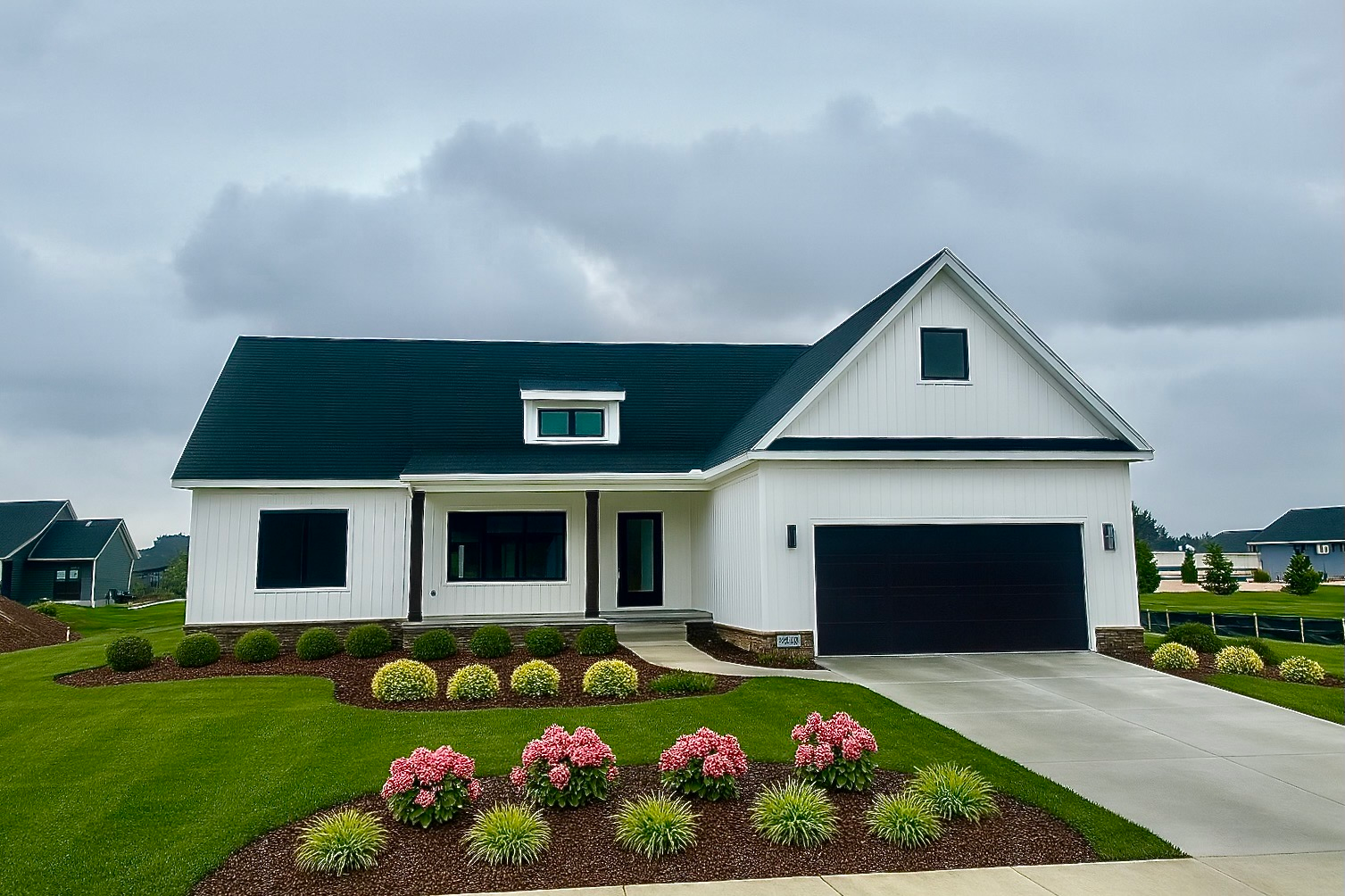 Model home exterior at Oaks of Tyrone by Big Sky Development, modern farmhouse style with white board-and-batten siding and stone accents