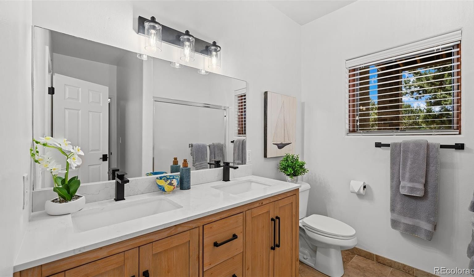 Modern bathroom with wood vanity and black fixtures