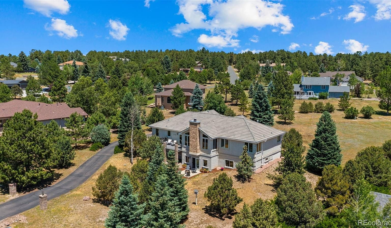 Elevated aerial view of home on wooded lot