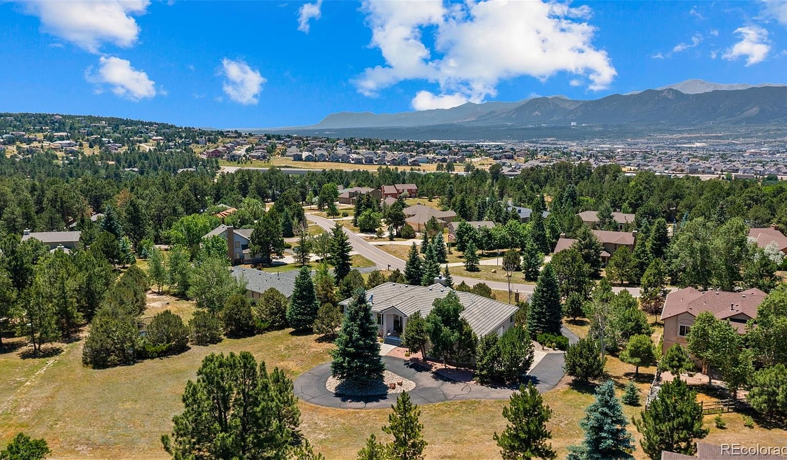 Aerial view of 830 Lake Woodmoor with Pikes Peak in background