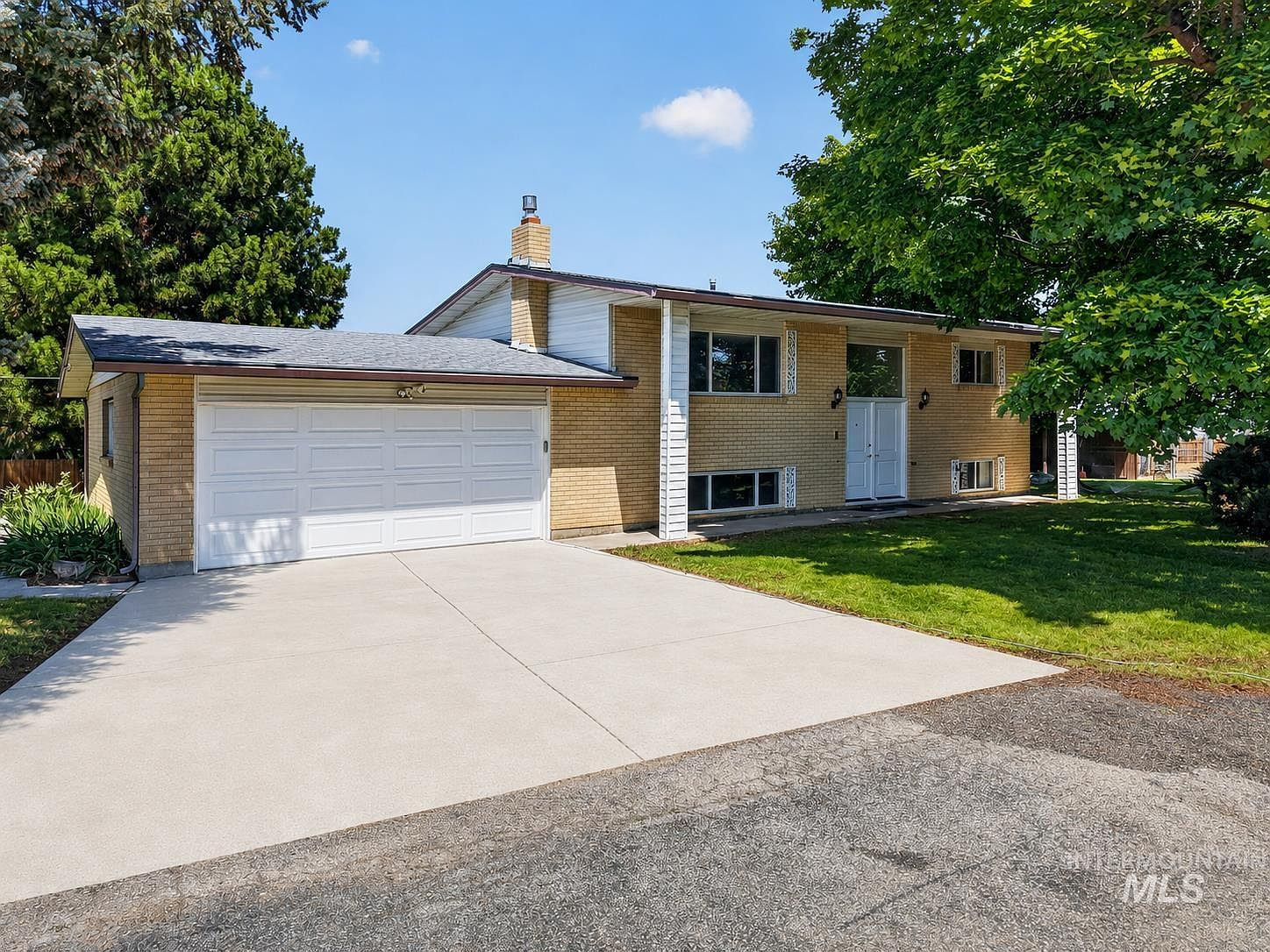Front exterior of 2590 S Cloverdale Rd, Boise, Idaho — split-level home with tan brick and white trim under clear blue sky