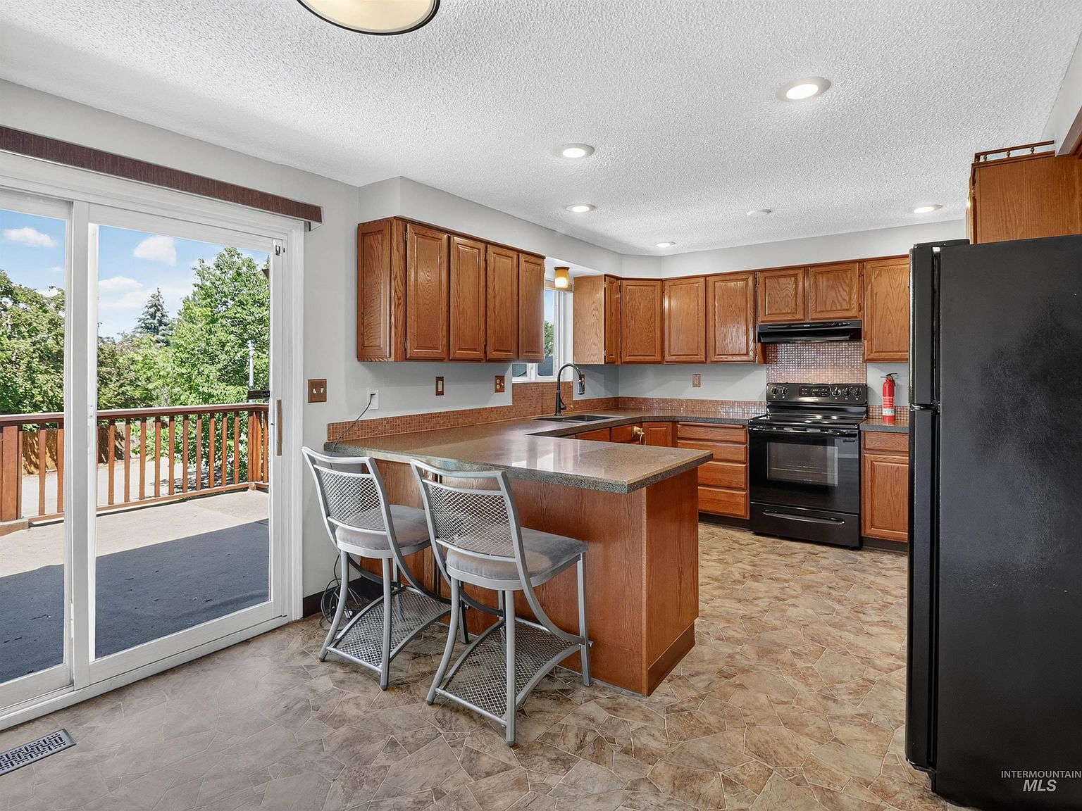 Main kitchen with oak cabinetry and sliding glass door to Trex deck
