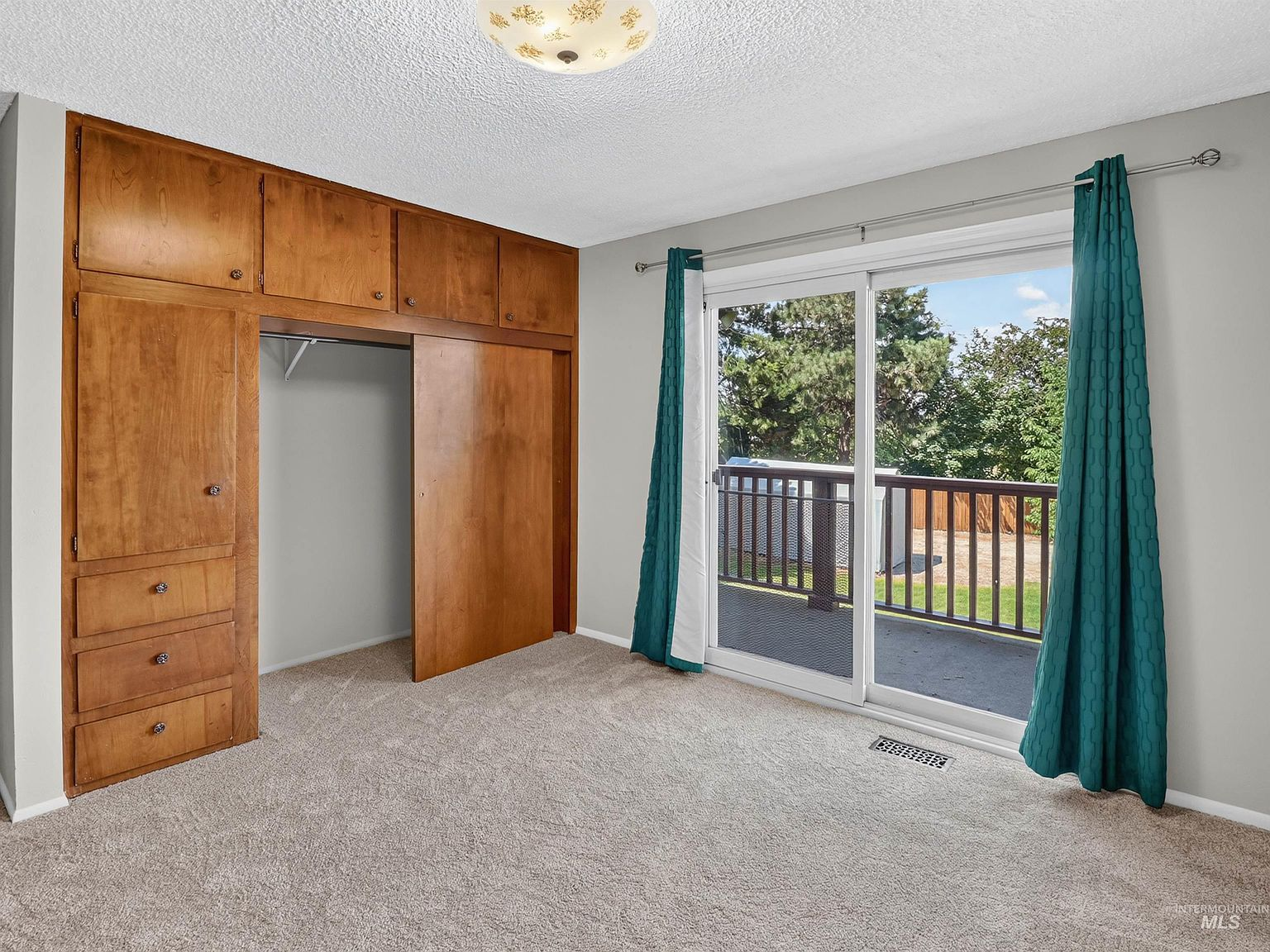 Primary bedroom with built-in cabinetry and balcony access
