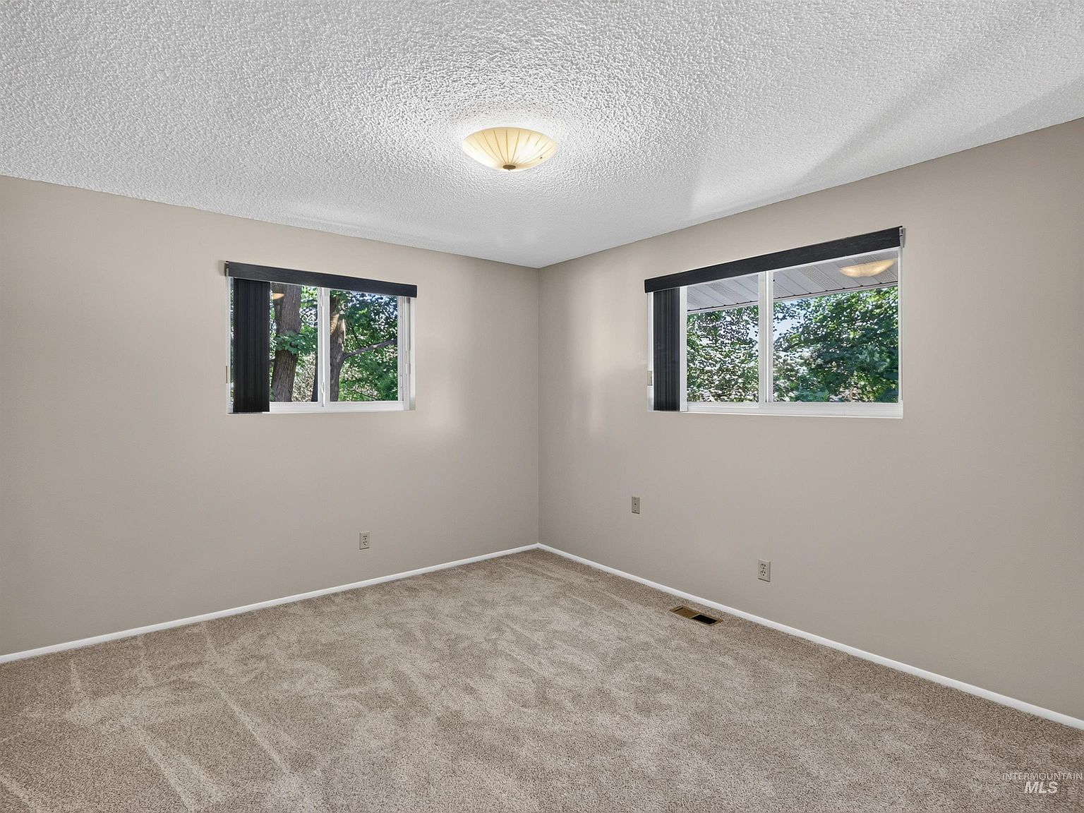 Neutral bedroom with carpet and dual windows