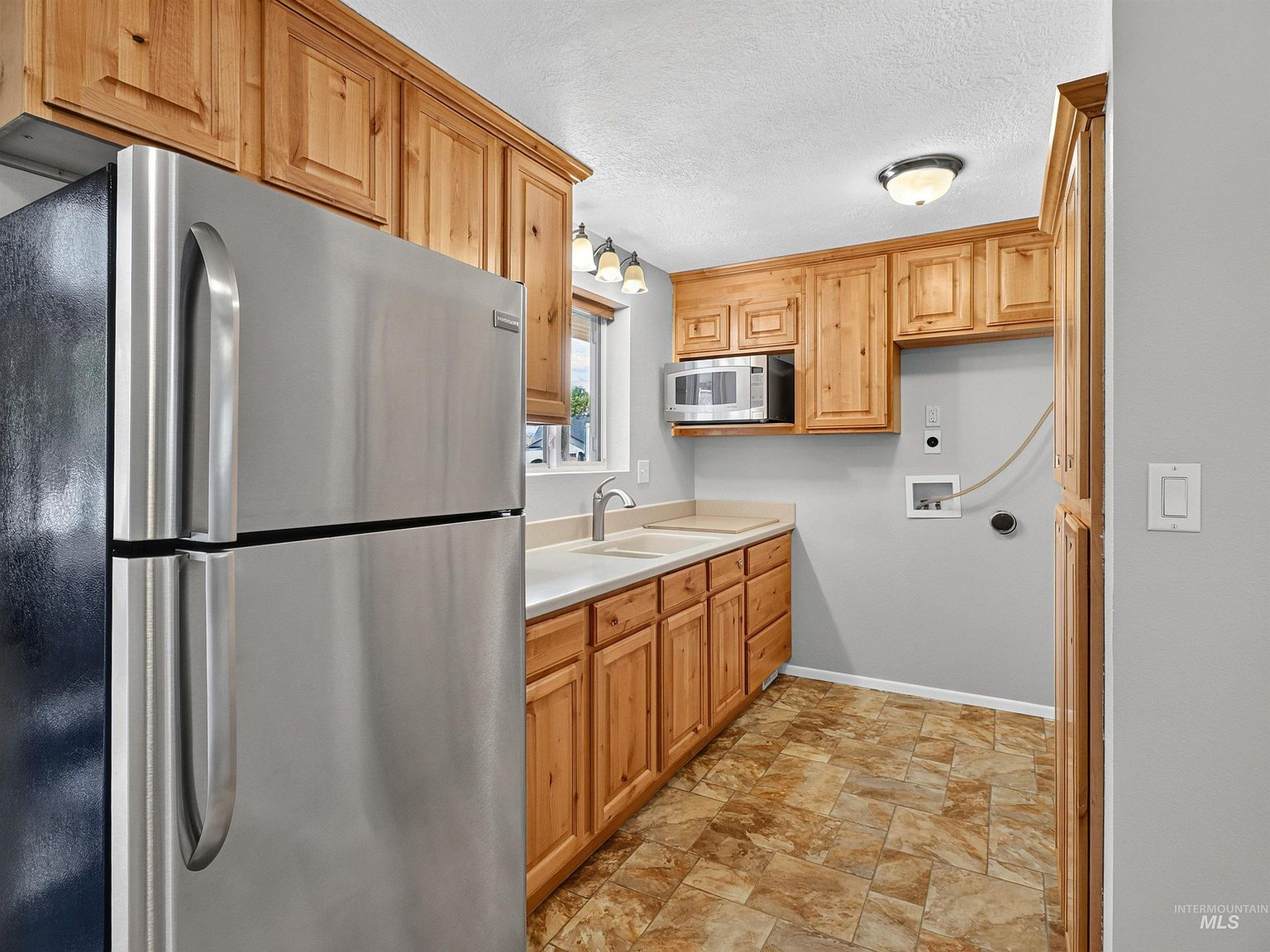 Secondary kitchen with natural wood cabinetry and stainless appliances