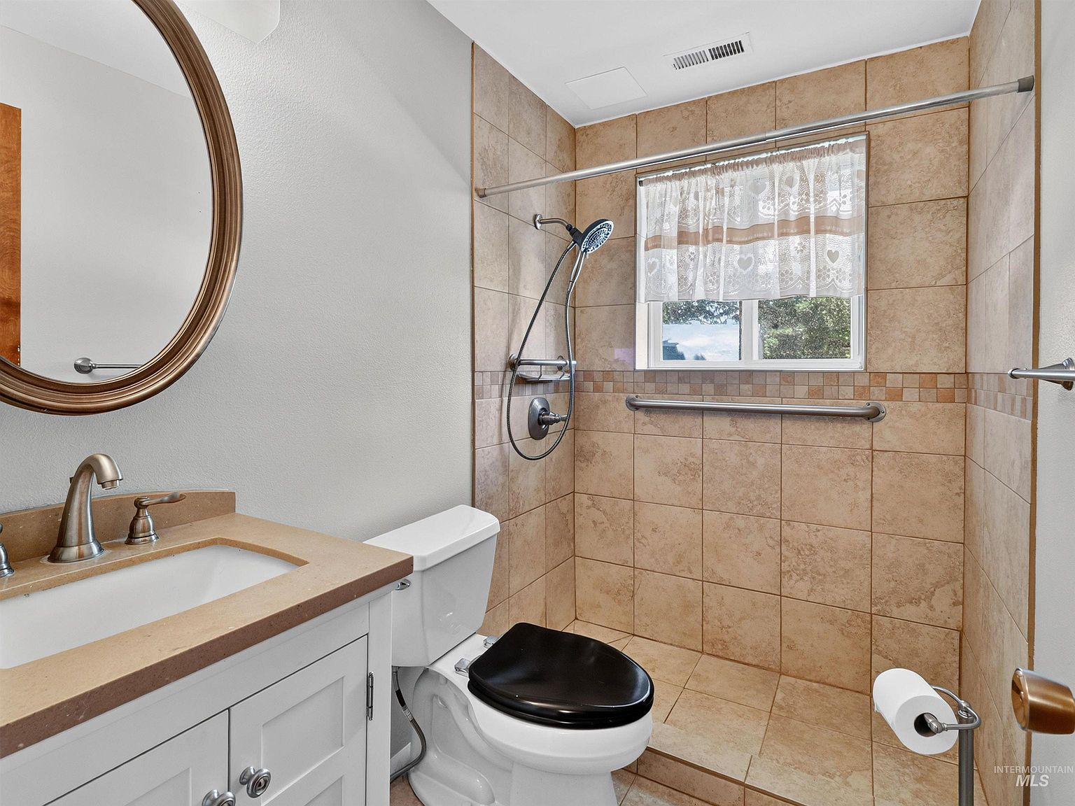 Lower level bathroom with beige tile and white vanity