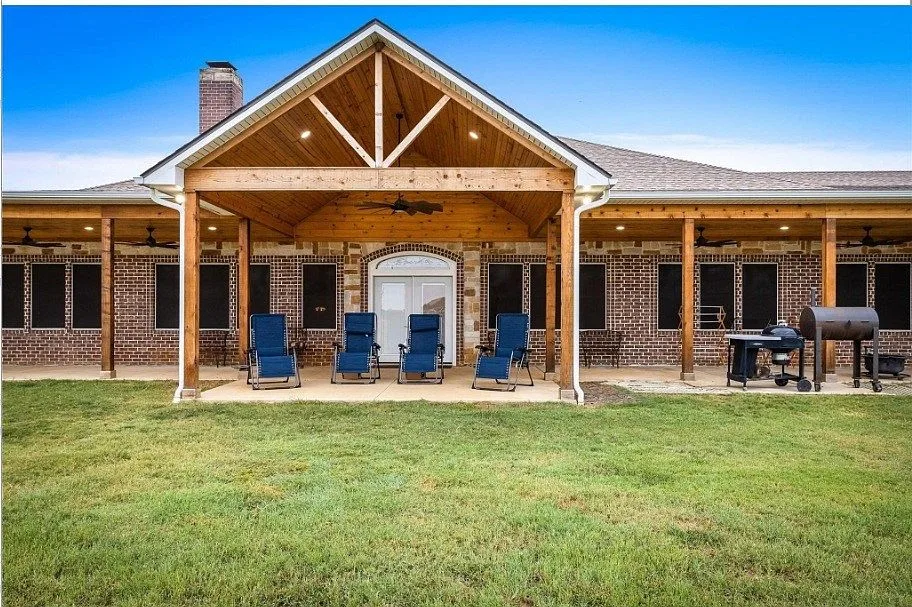 Expansive timber-frame covered porch with pastoral views