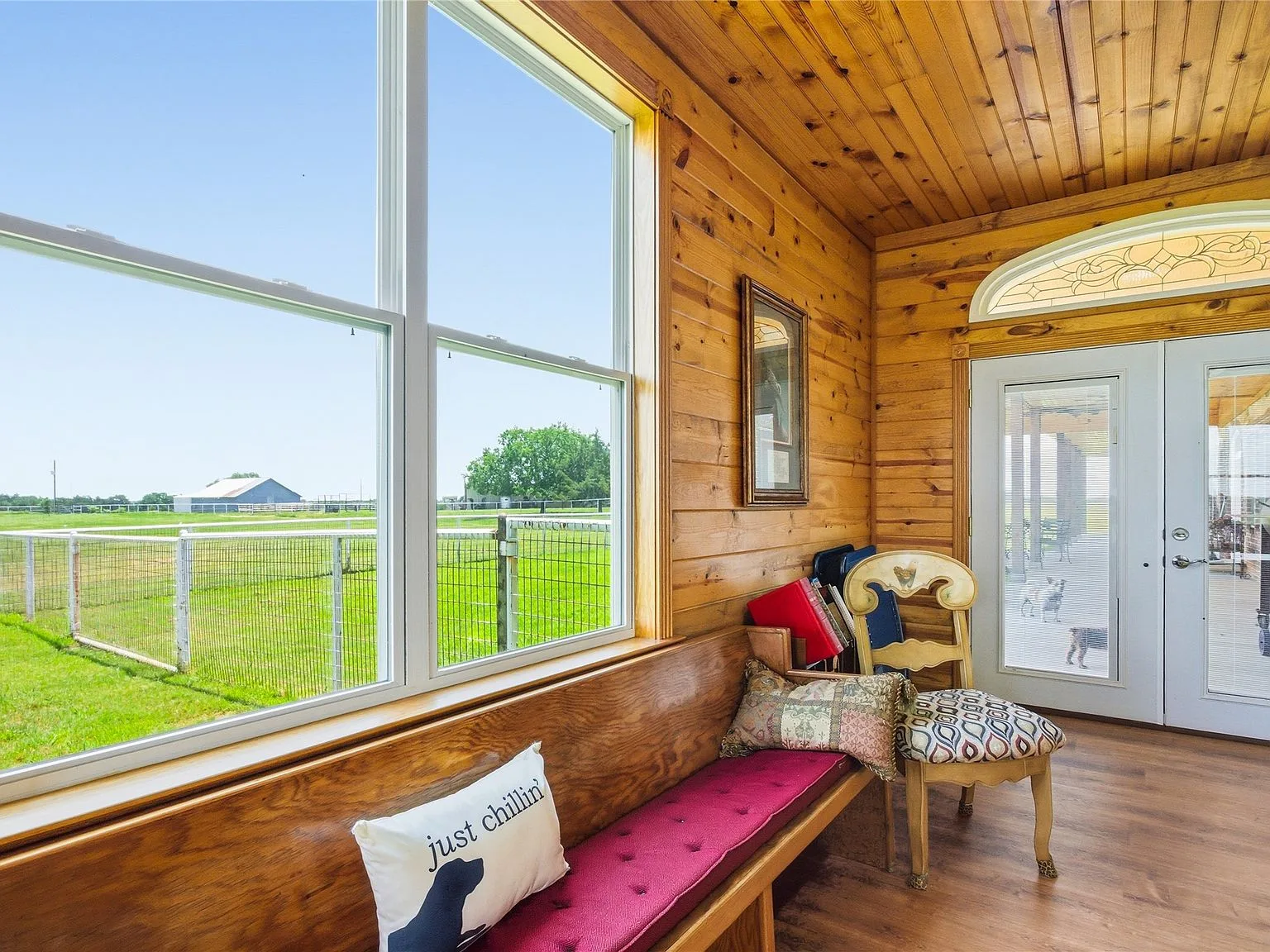 Sunroom with wood-paneled walls and stained glass transom