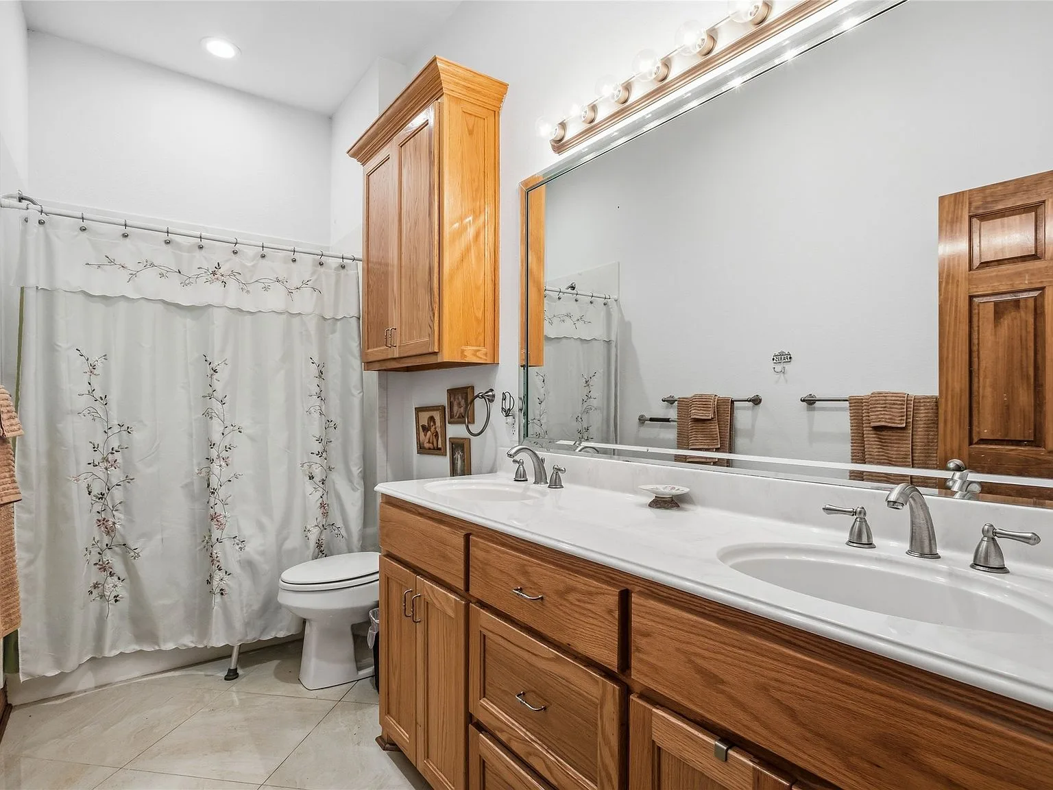 Ranch estate bathroom with natural wood cabinetry